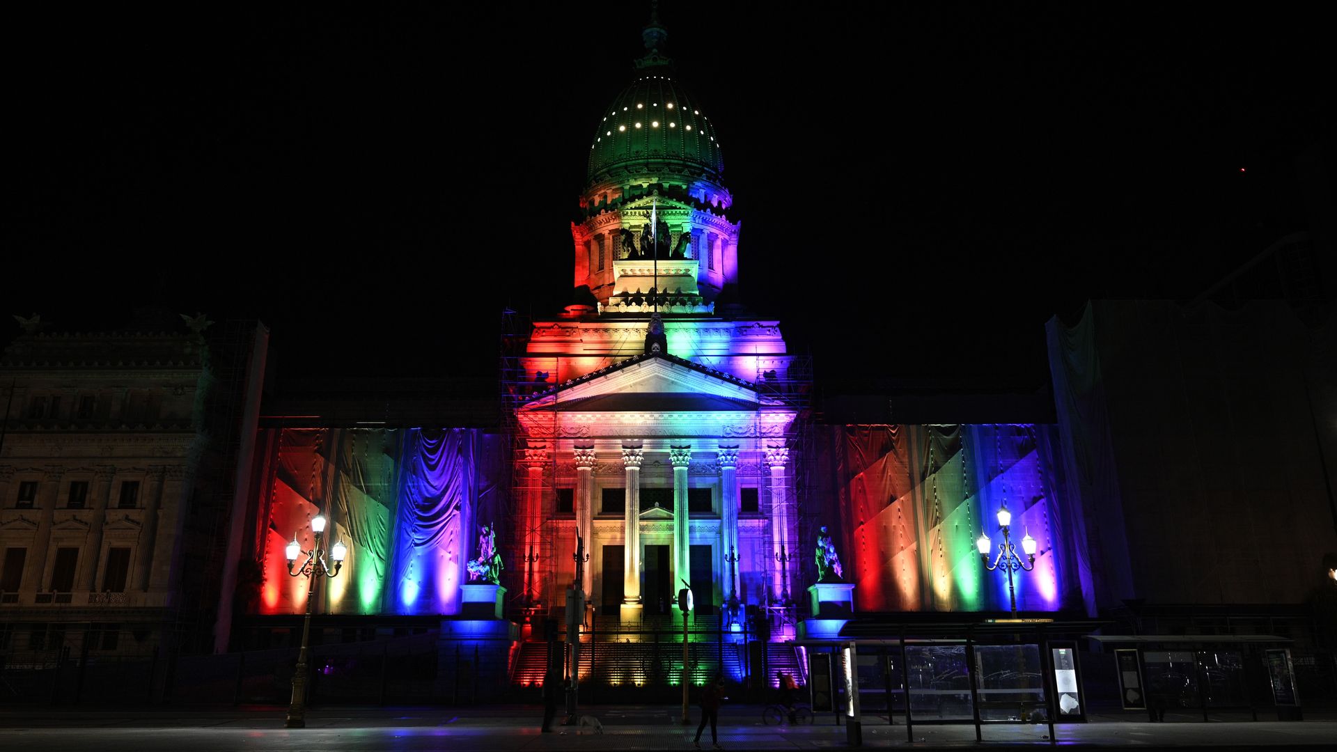 Photo of the Argentinian Congress lit up in rainbow colors against a night sky