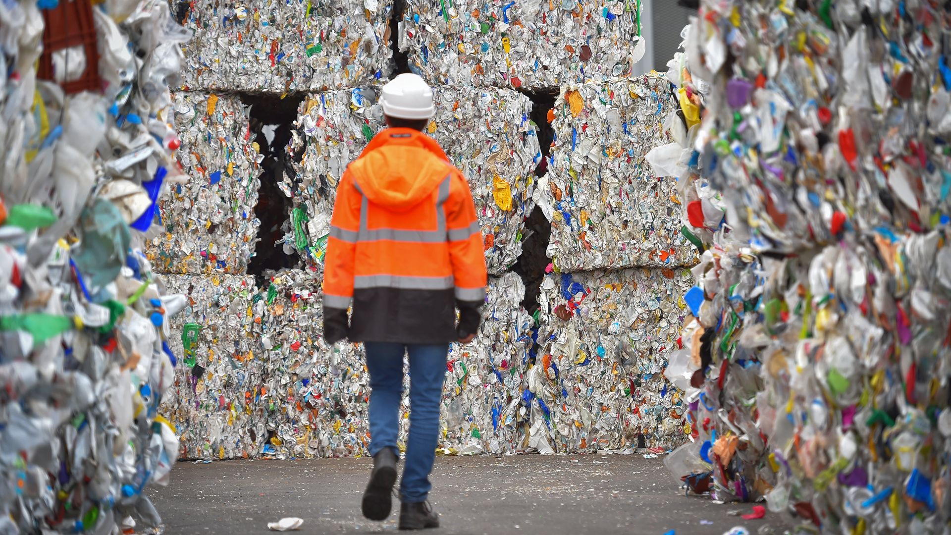 An employee walks through plastic wastes waiting to be recycled at a sorting center in France