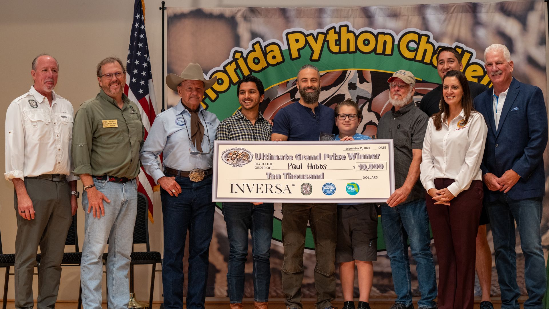 A group of people holds a giant symbolic check