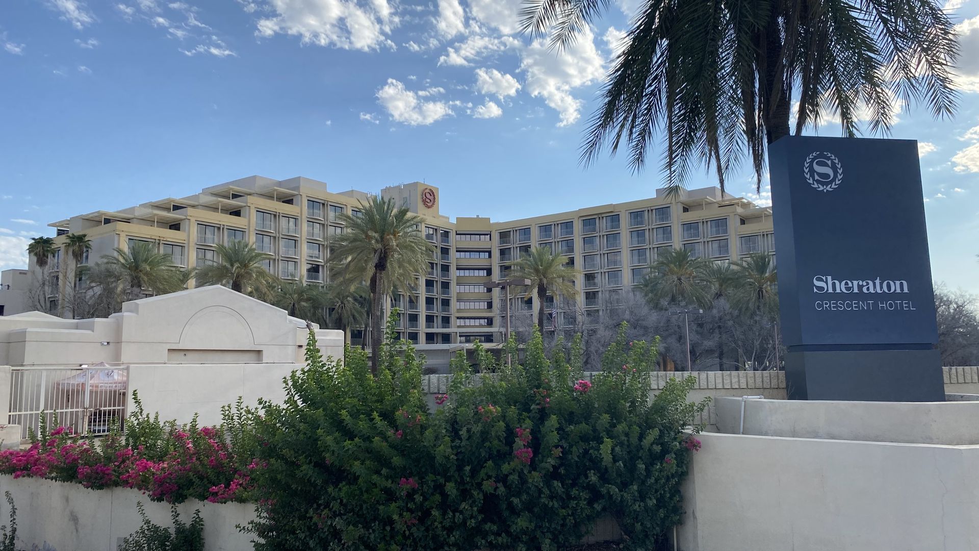A large luxury hotel with a sign in front identifying it as the Sheraton Crescent Hotel.
