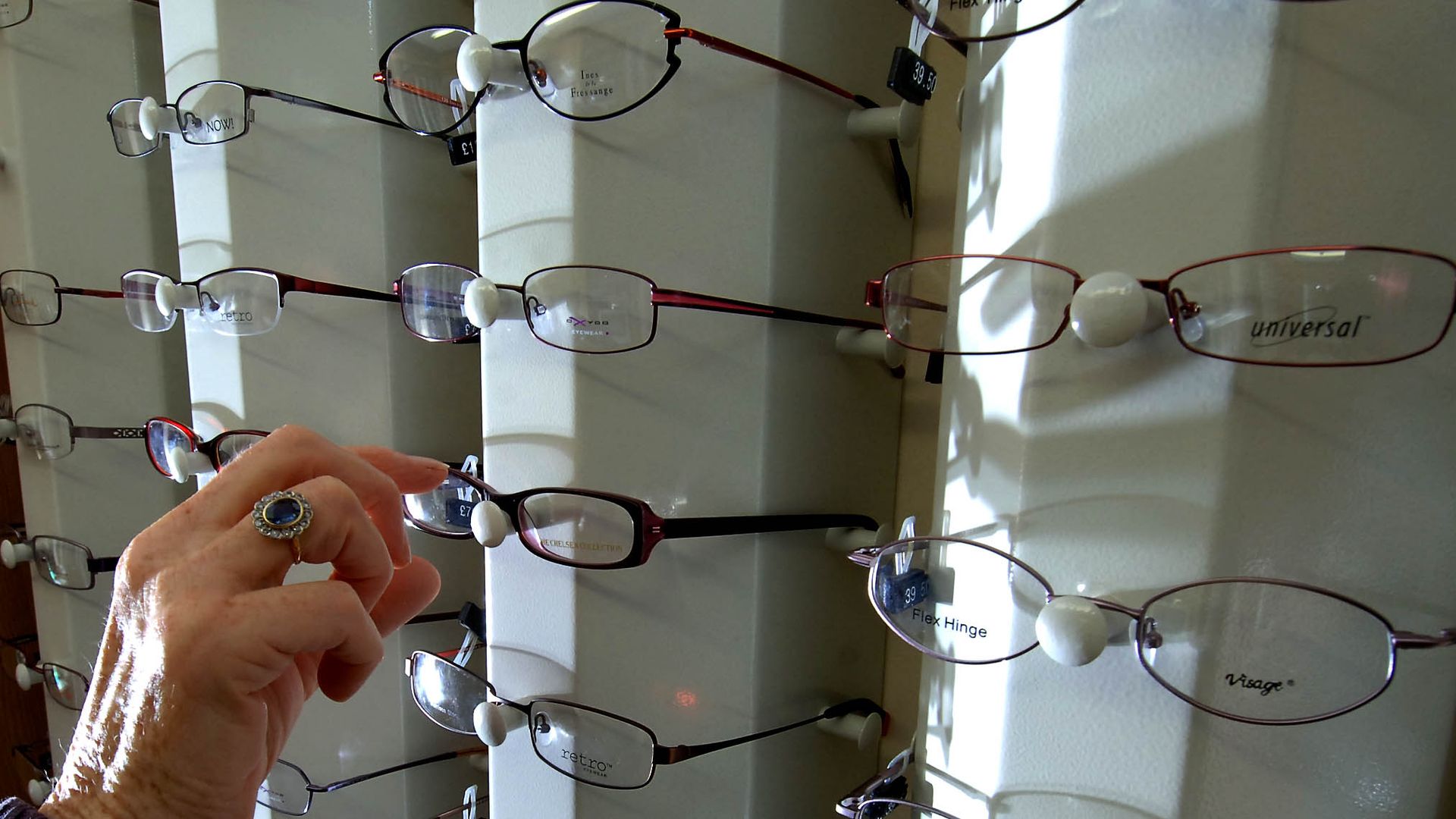 someone picking out eye glasses at a doctors office