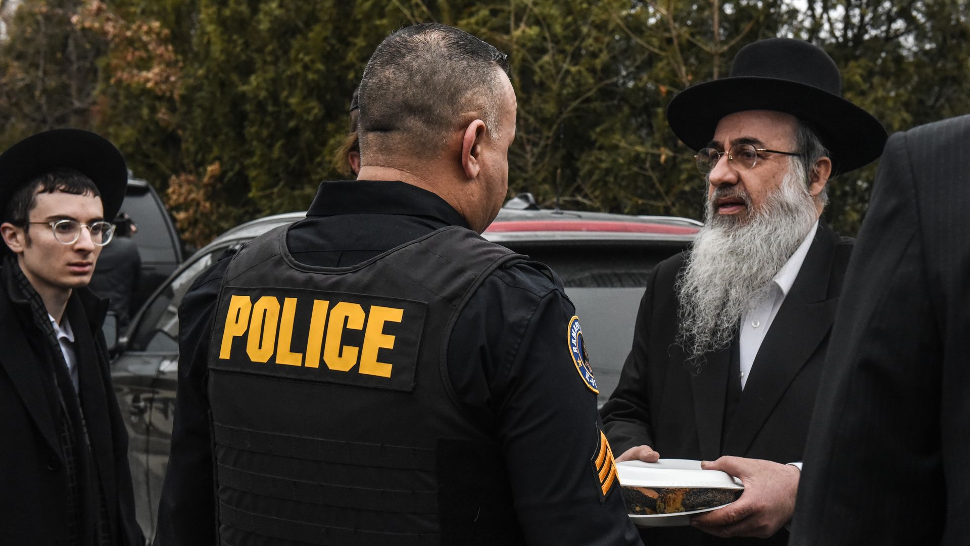 A Ramapo police officer stands guard in front of the house of a rabbi