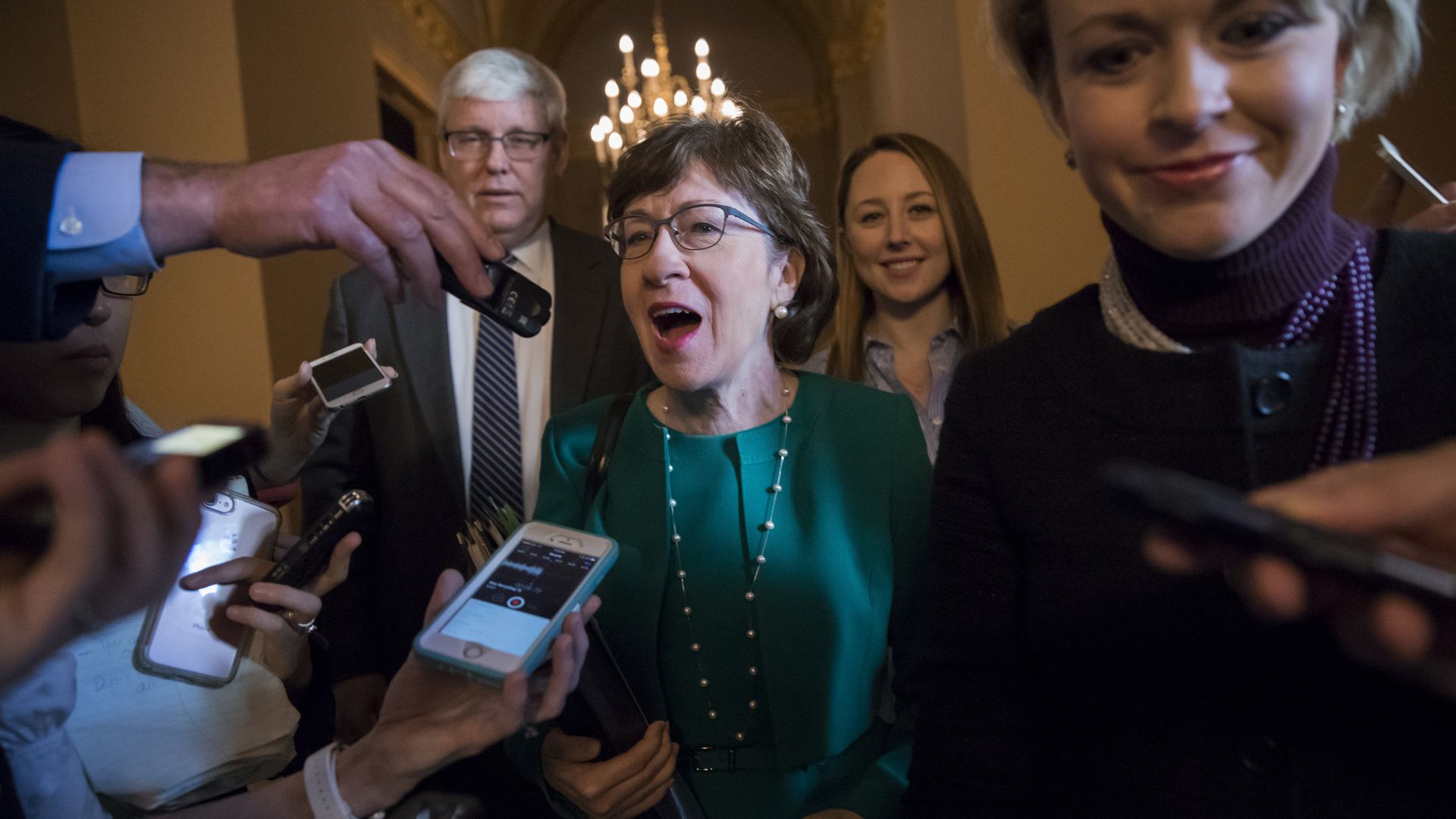 Sen. Susan Collins, R-Maine, makes her way through a crush of reporters.