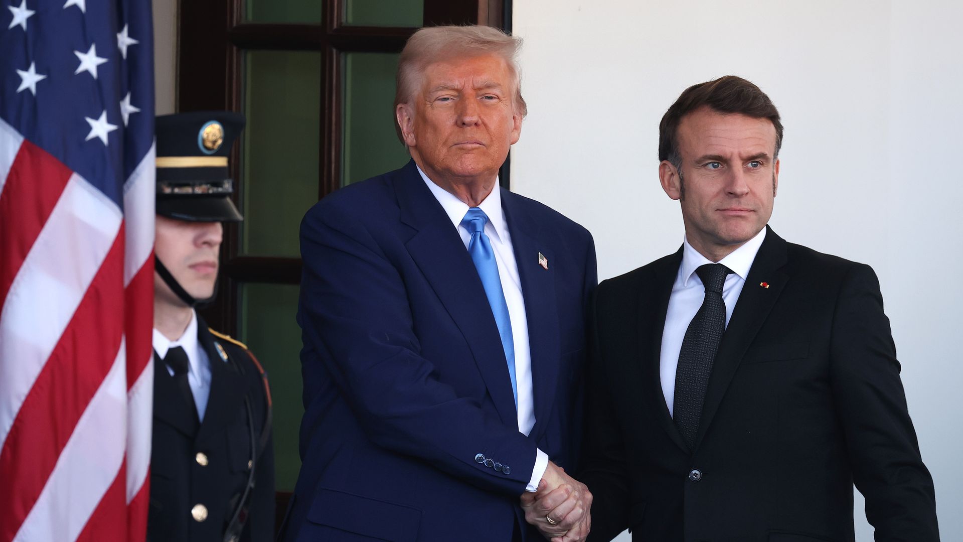President Donald Trump (L) greets French President Emmanuel Macron as he arrives at the White House for a meeting on February 24, 2025 in Washington, DC. 