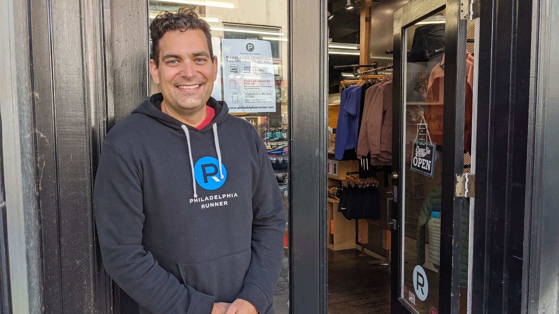 Michael Zabrodski, manager of the Philadelphia Runner's Manayunk location, stands in front of the store's doors on Main Street. 
