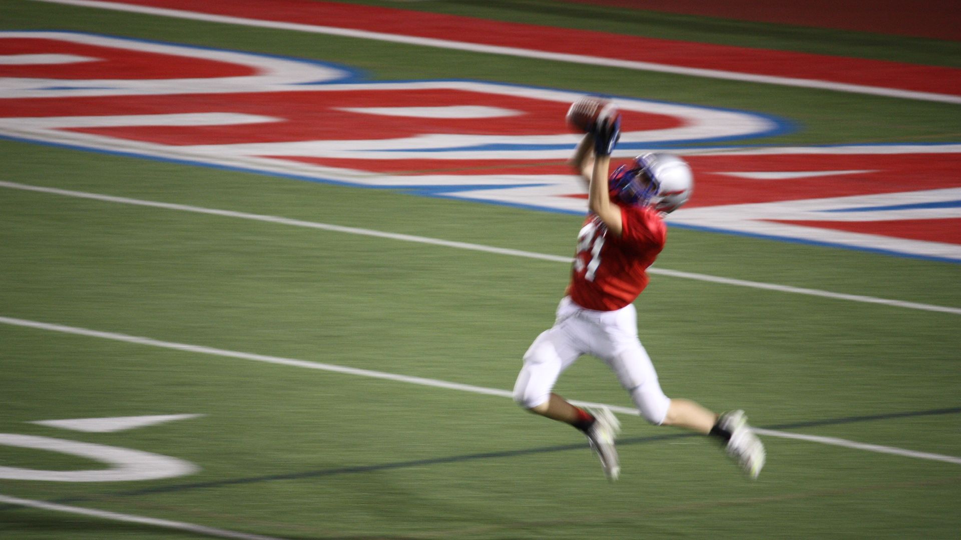 A photo of Reeves catching a football on the field.