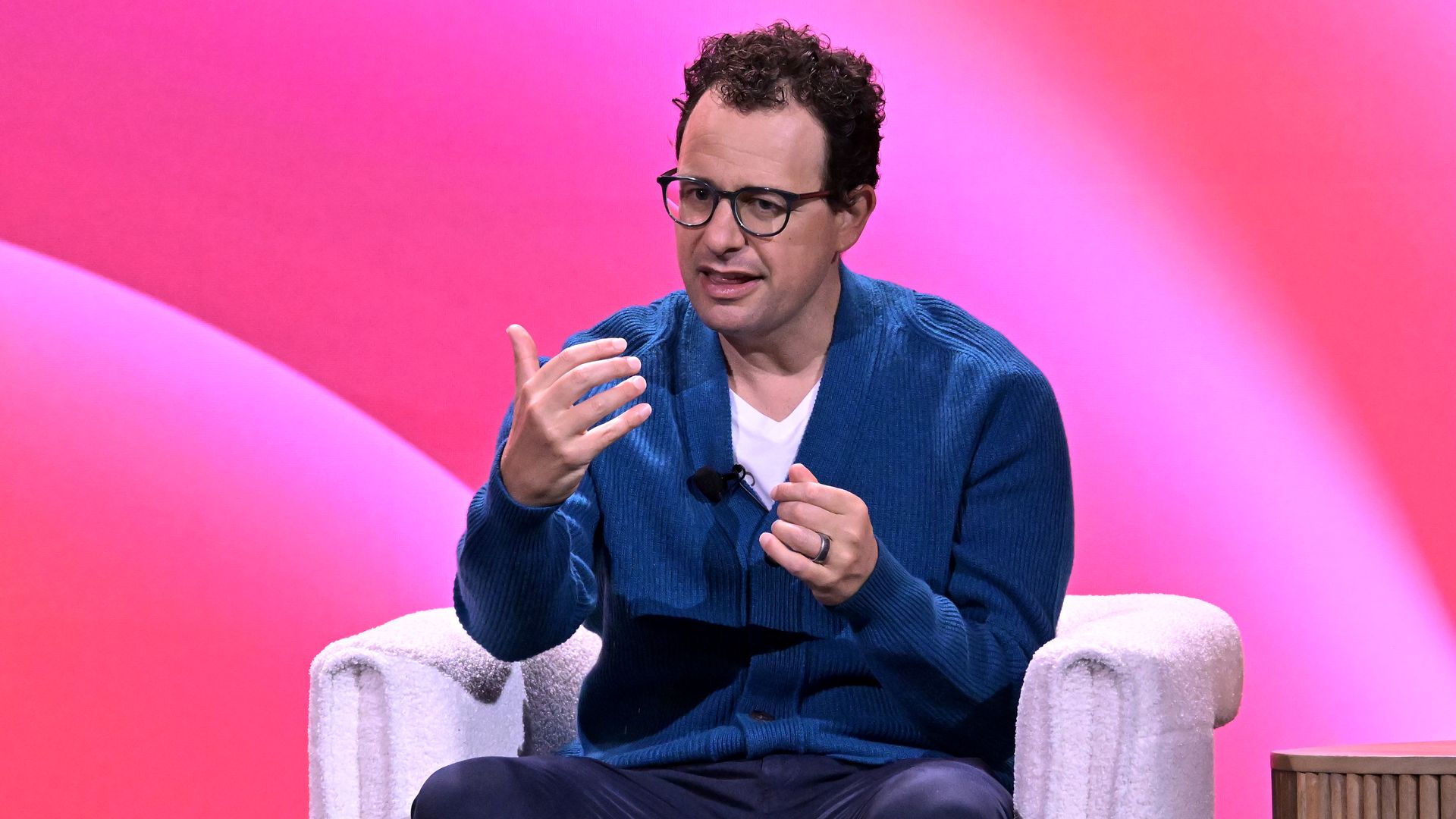 Anthropic CEO Dario Amodei sitting down and gesturing. 