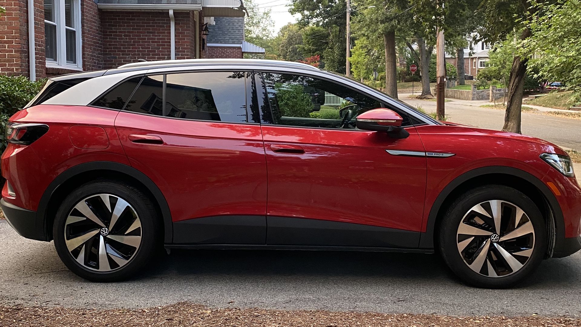 A photograph of a red VW ID.4 electric crossover SUV, from the passenger side of the vehicle.