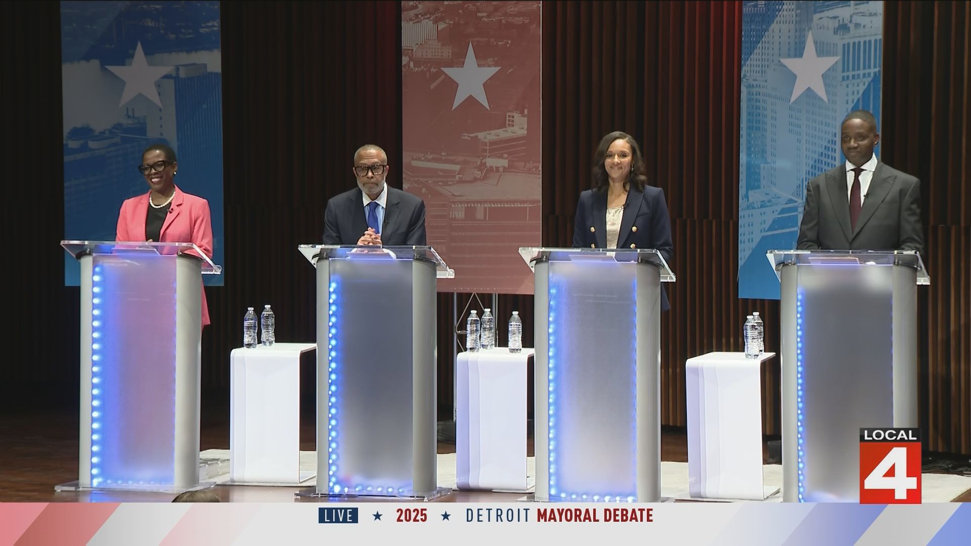 The four candidates stand on stage