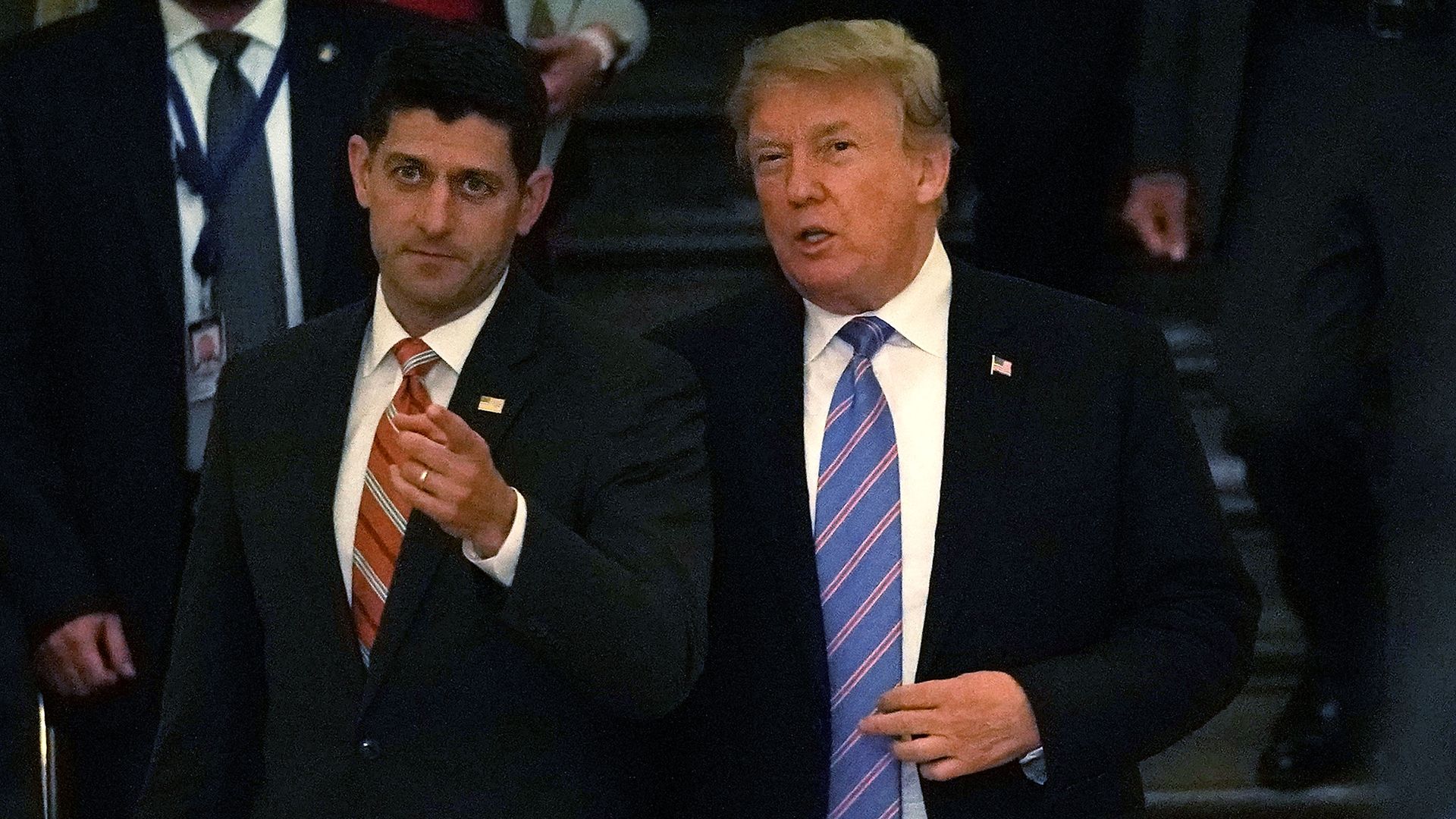 Donald Trump and Paul Ryan standing next to each other talking but facing the camera directly ahead of them