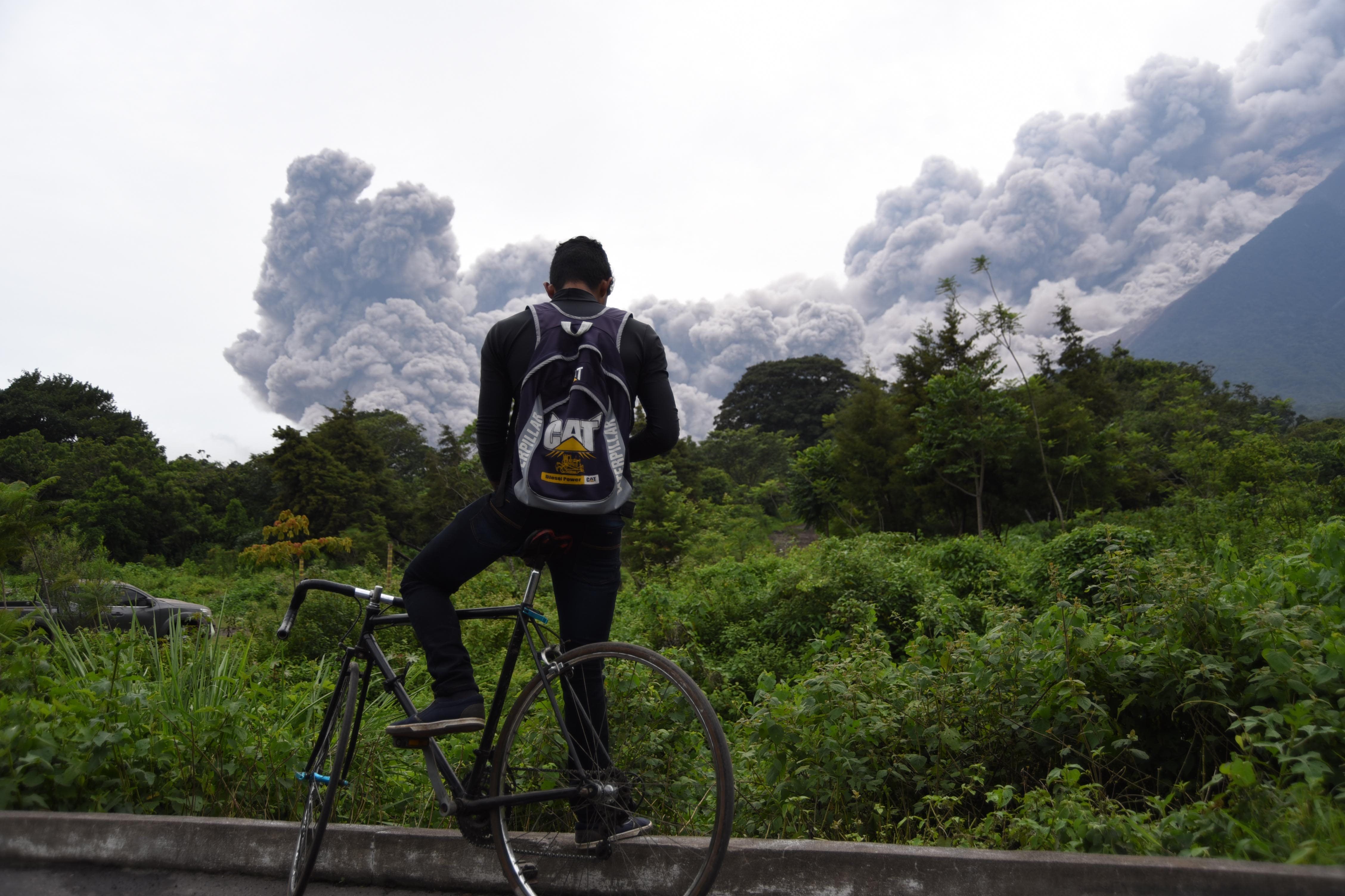 A man looks at the Fuego Volcano in eruption