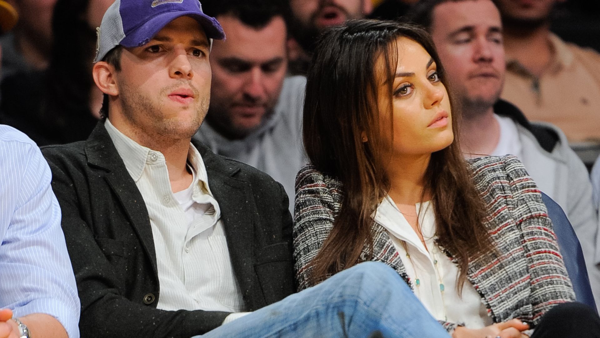 Ashton Kutcher and Mila Kunis at a basketball game.