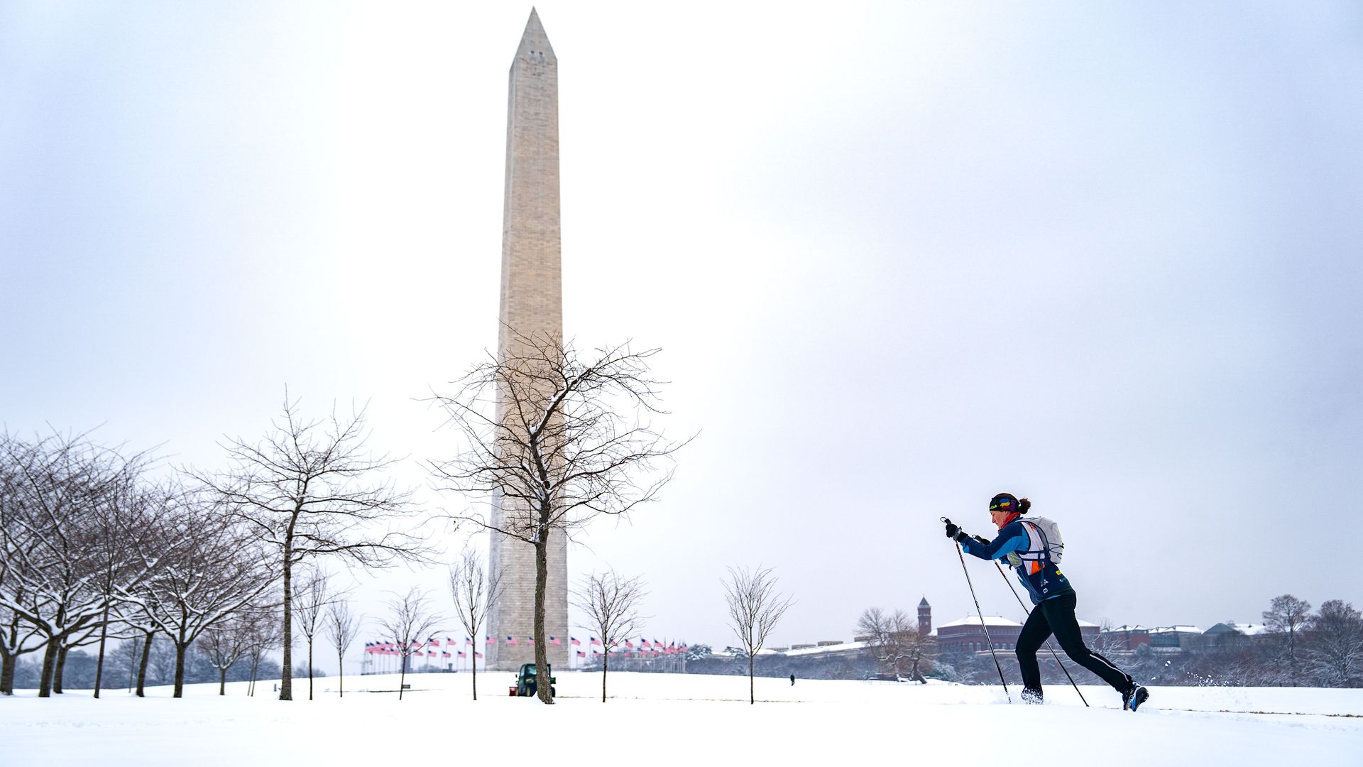 Snow covers the National Mall on February 12, 2025 while a person cross country skis in front of he Washington Monument. 
