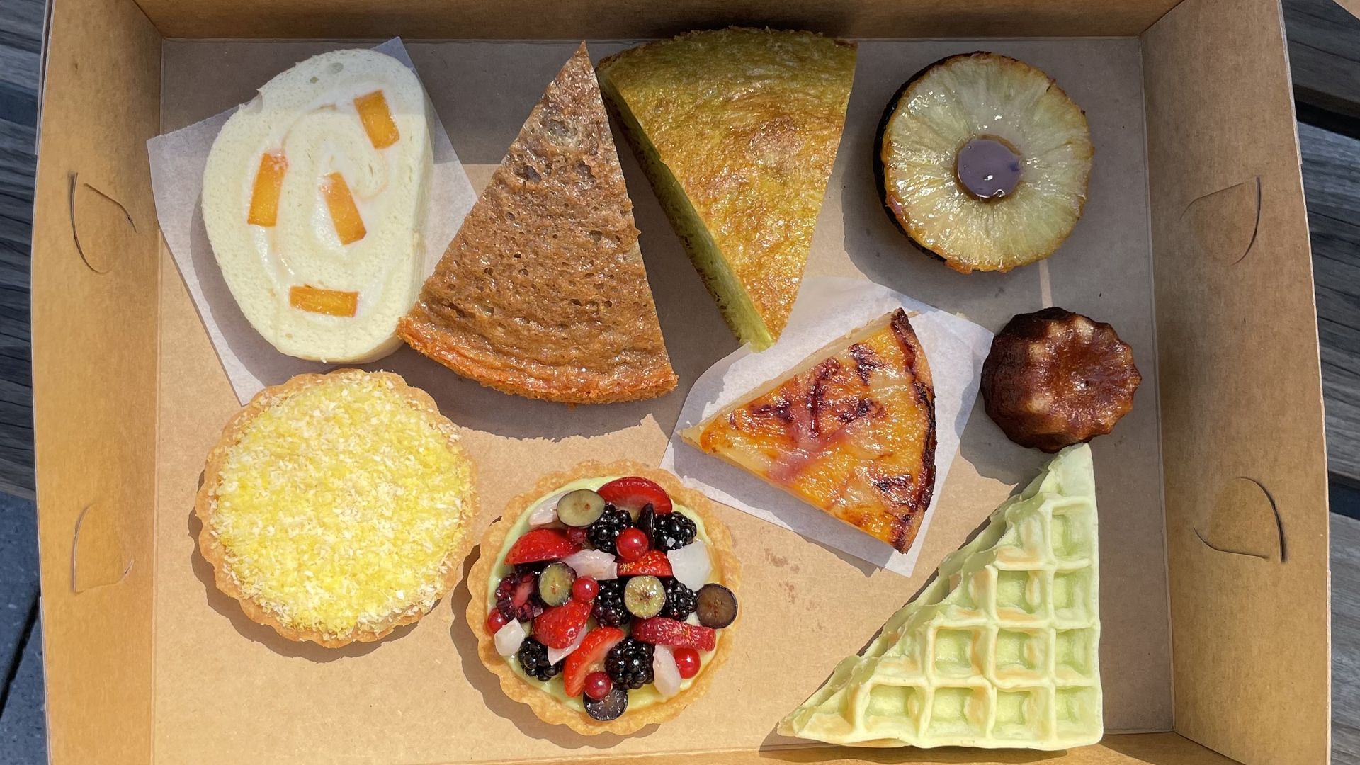 A photo of a cardboard box with nine pastries inside.