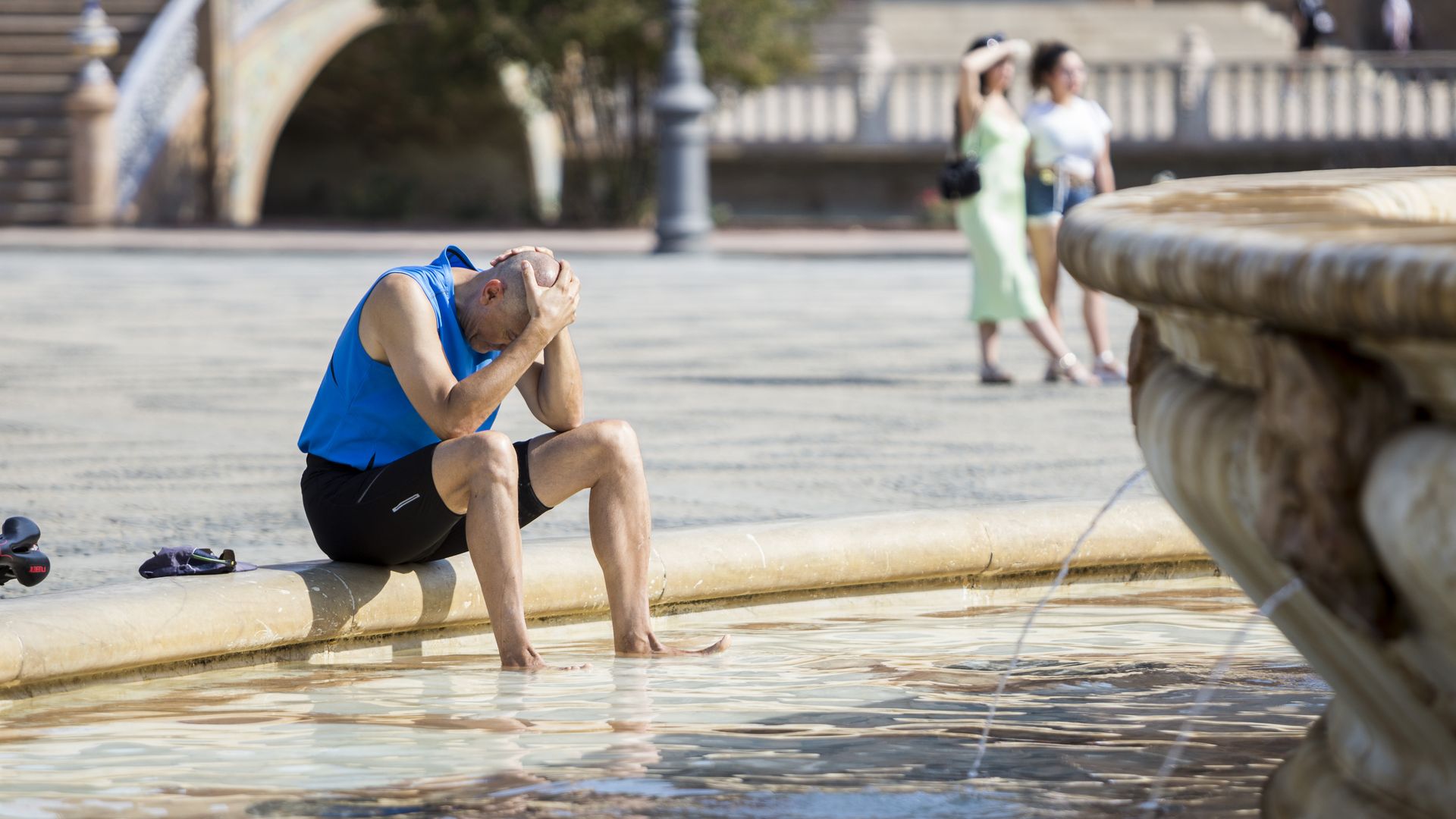 A man cools off in the central fountain in the Plaza de España in Seville.
