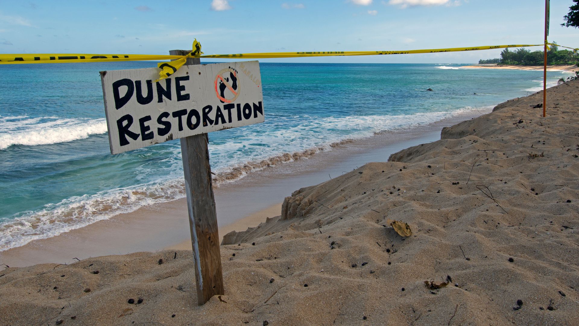 Photo of a beach taped off to the public with a sign that says "Dune restoration, no entering"