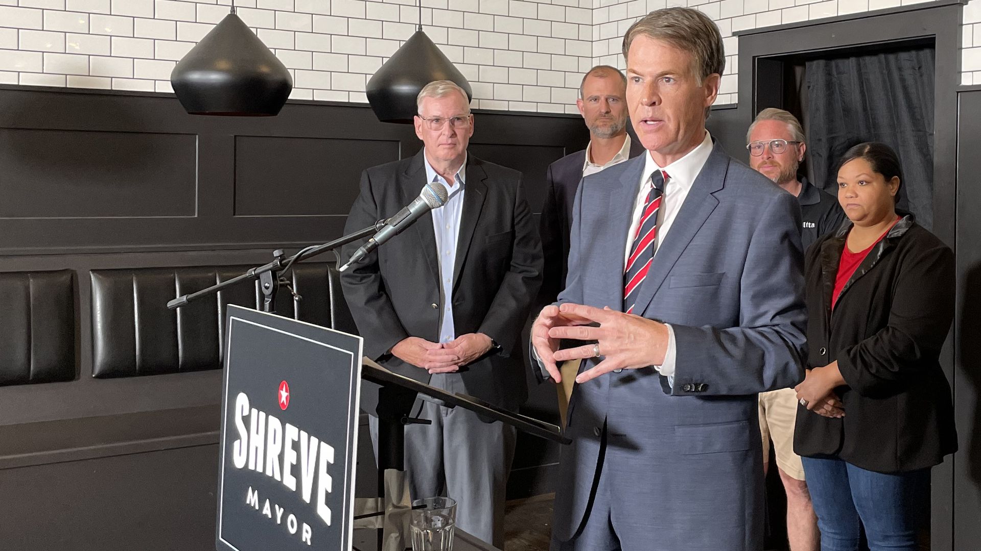 Republican mayoral candidate Jefferson Shreve speaks at a lectern as supporters look on.