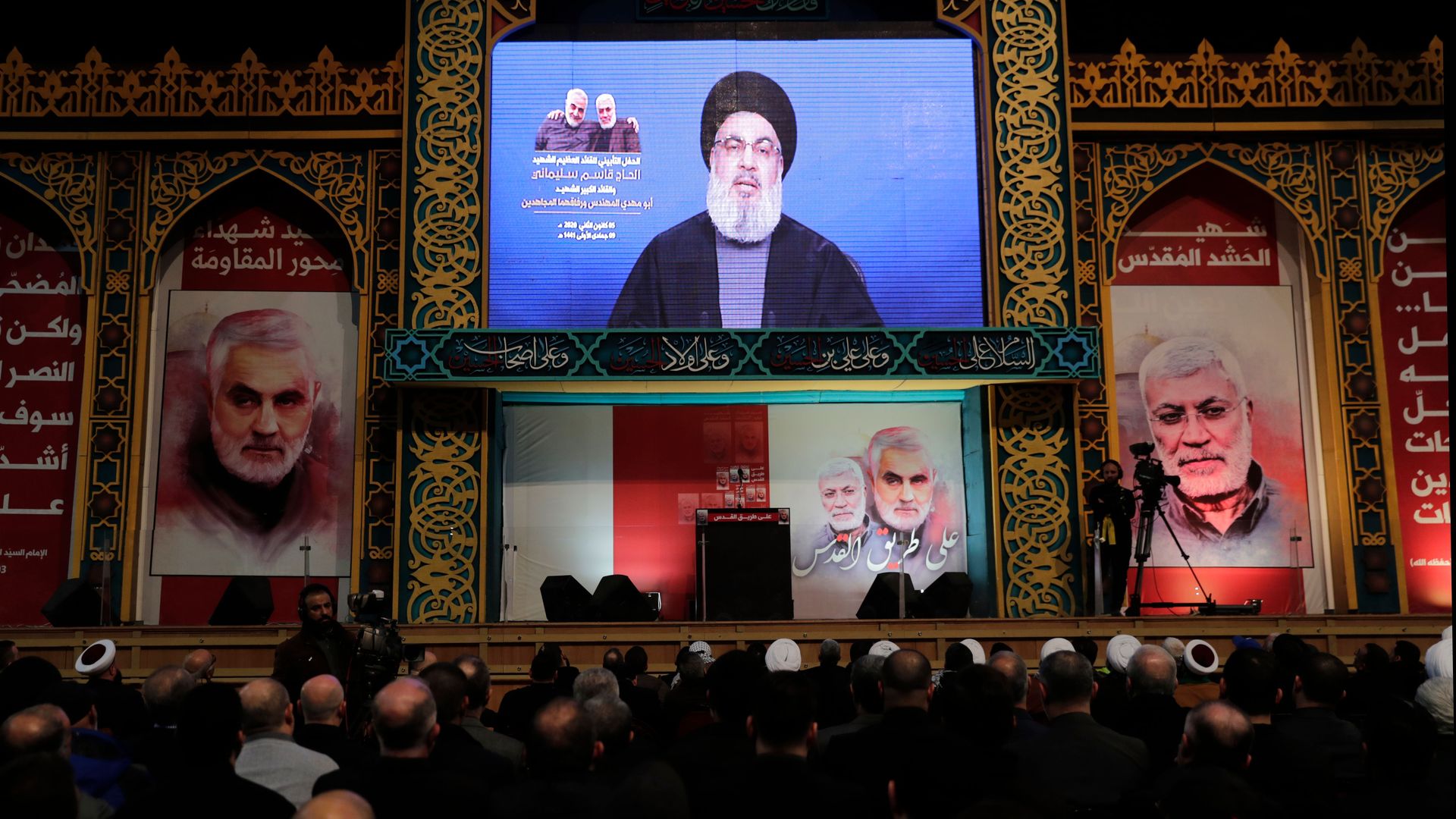 Supporters of the Hezbollah watch the movement's leader deliver a speech