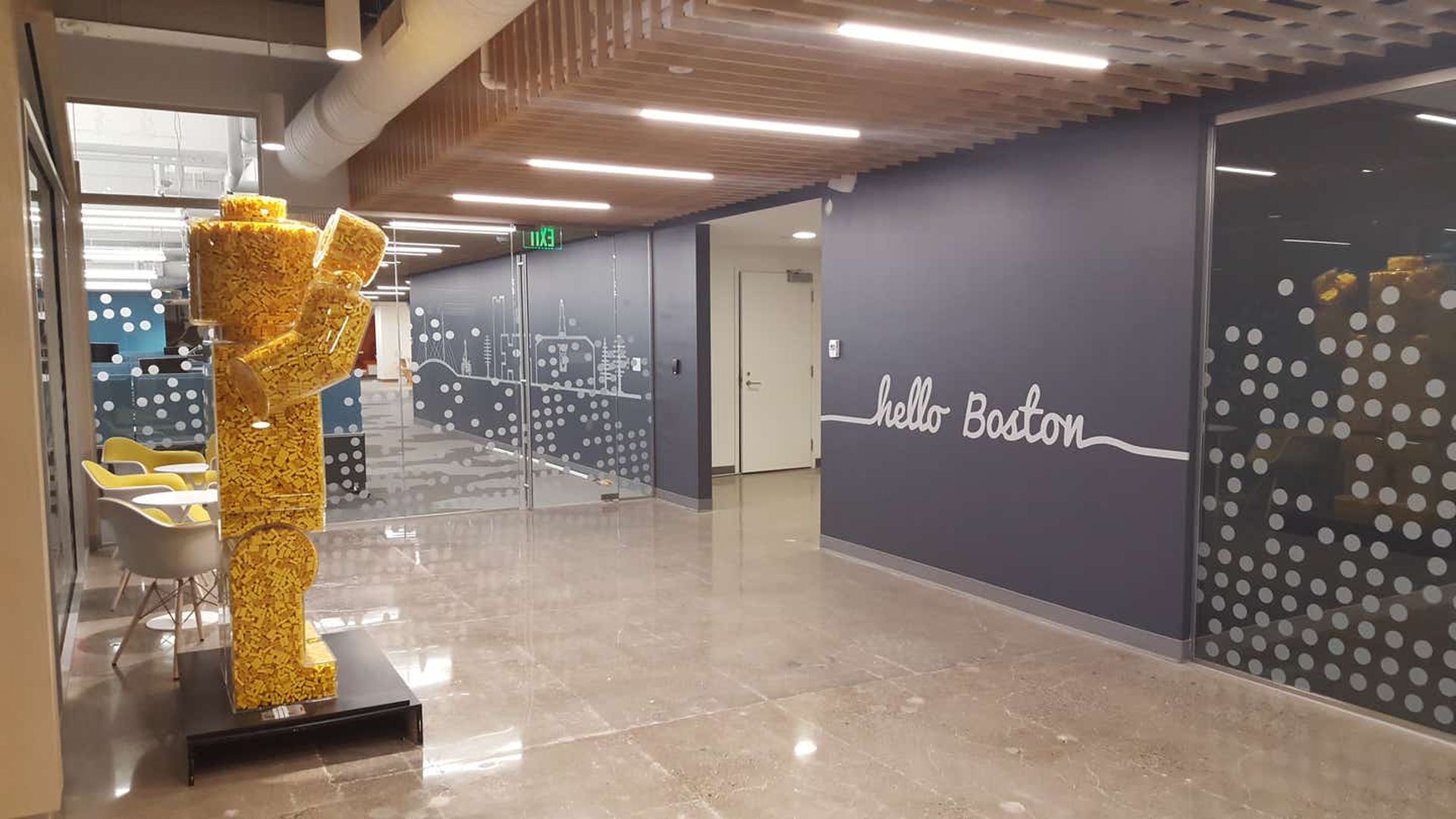 Inside the lobby of Lego's education office in Boston is a life-size yellow minifigure made up of thousands of tiny yellow legos, to the left of the glass doors.