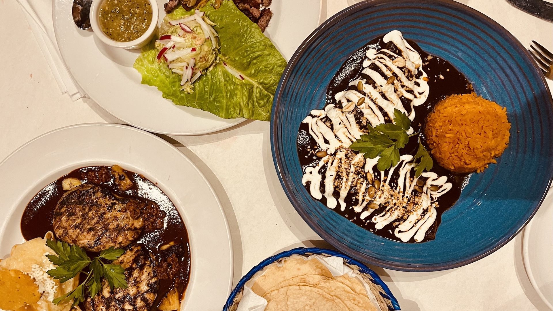 Plates with mole and a plate of tortillas.