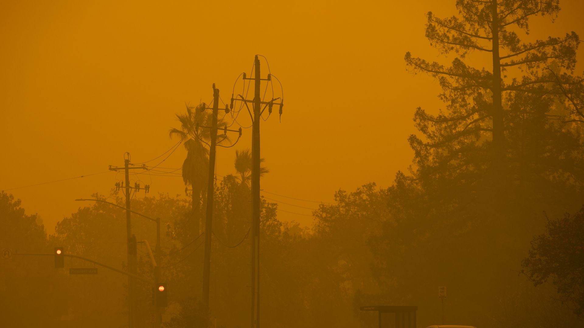 Kincaide fire creates eerie smoky orange glow in sky and surrounding a street with power lines
