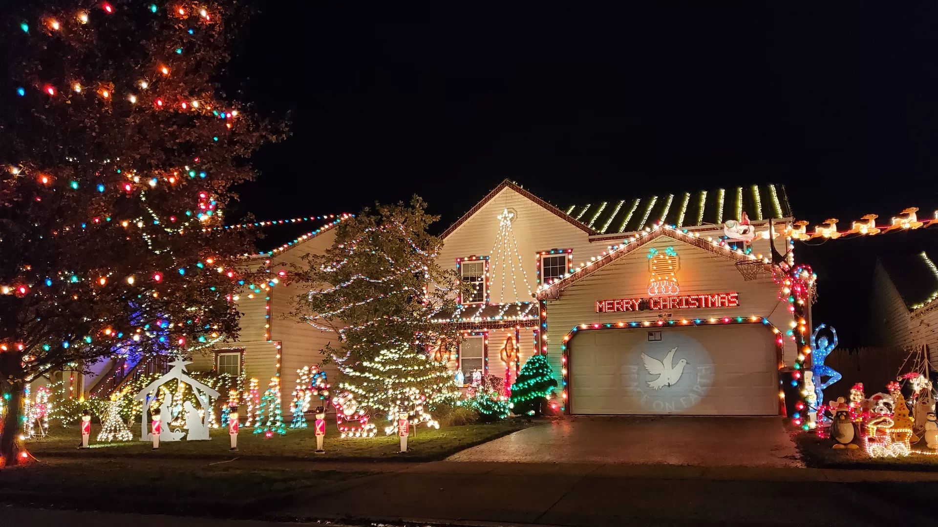 A house decorated with Christmas lights that reads "Merry Christmas" on the garage