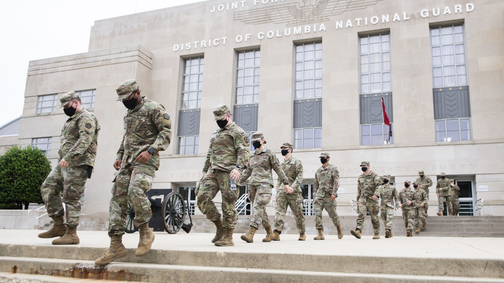 Photo of National Guard soldiers in uniform walking out of the D.C. National Guard building in formation