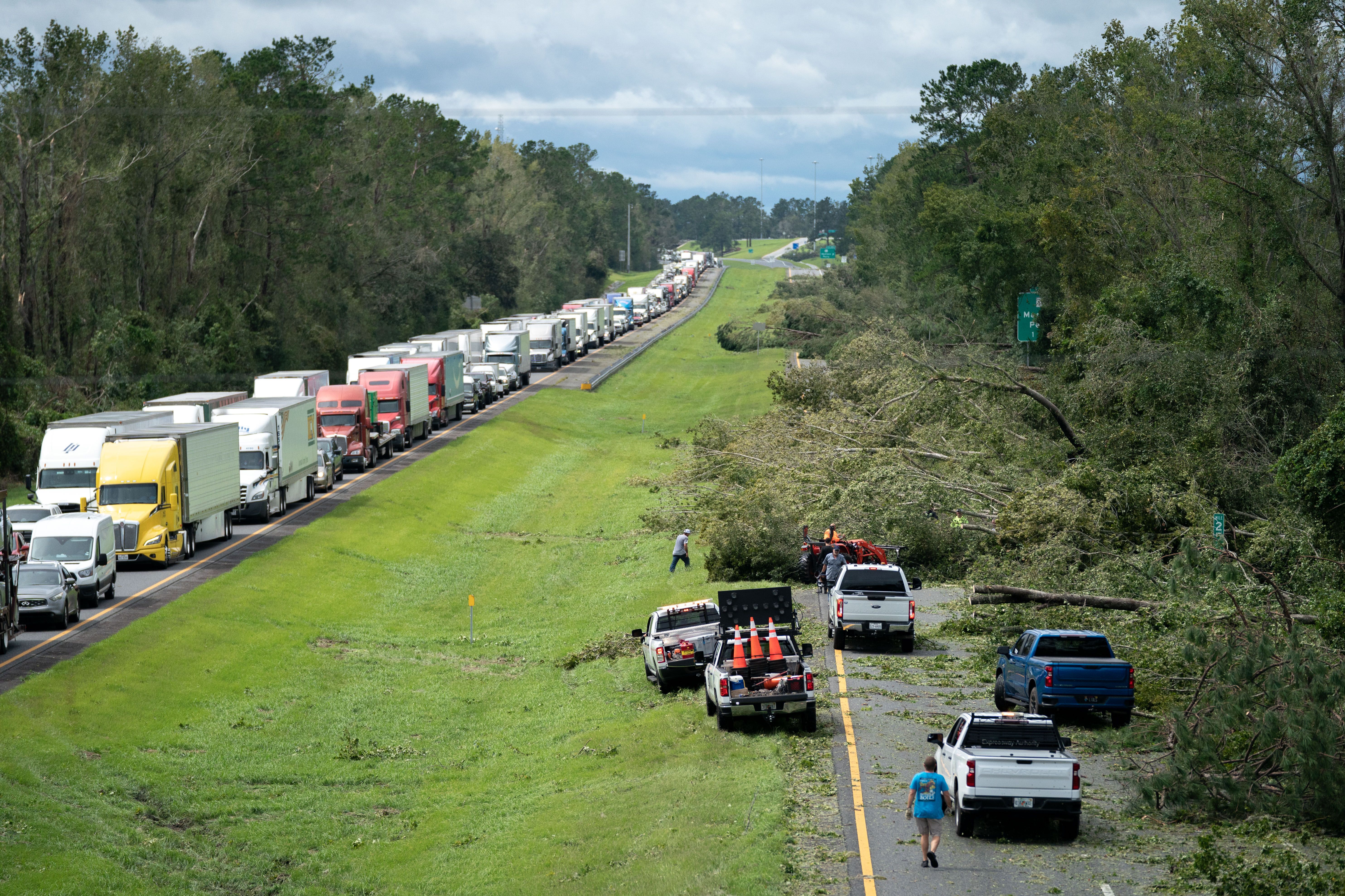  People work to clear I-10 of fallen trees after Hurricane Idalia crossed the state on August 30, 2023 near Madison, Florida. The storm made landfall at Keaton Beach, Florida as category 3 hurricane.