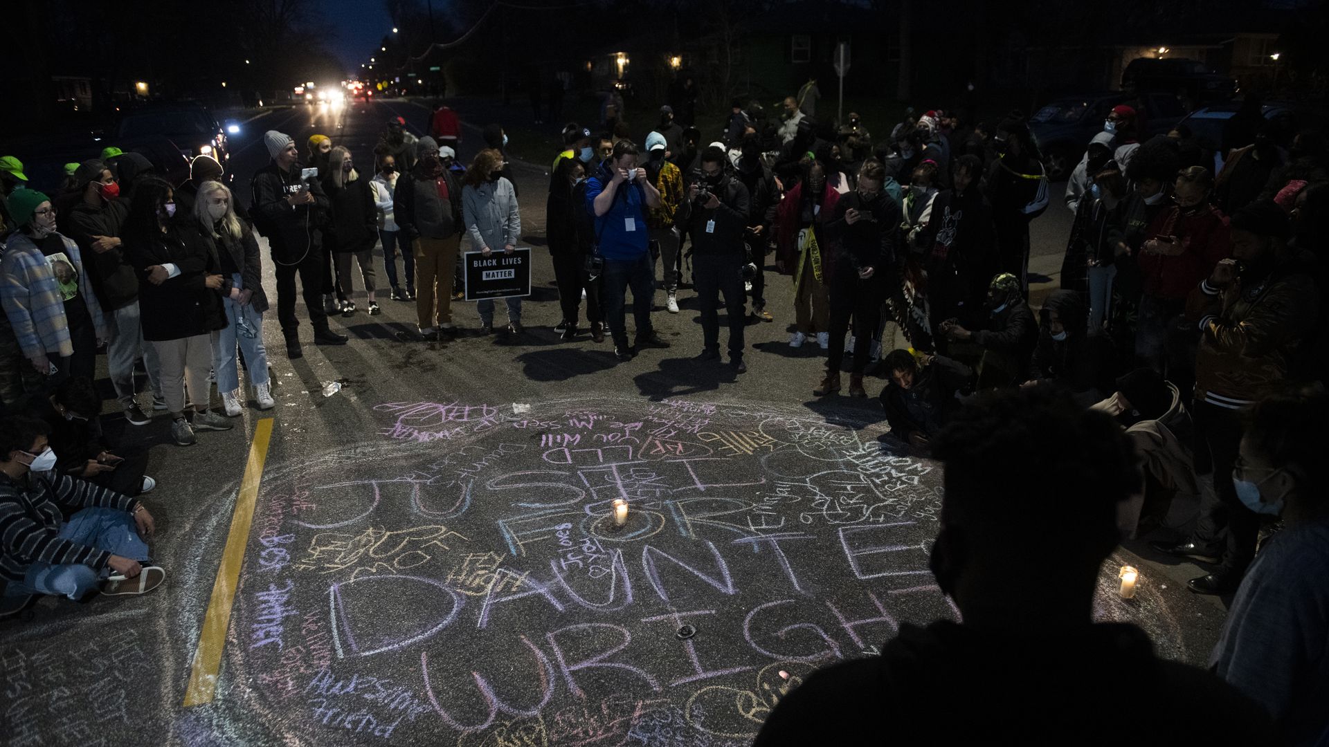 Protesters create a chalk circle that reads "Justice for Daunte Wright" in the street on April 11, 2021 in Brooklyn Center, Minnesota.