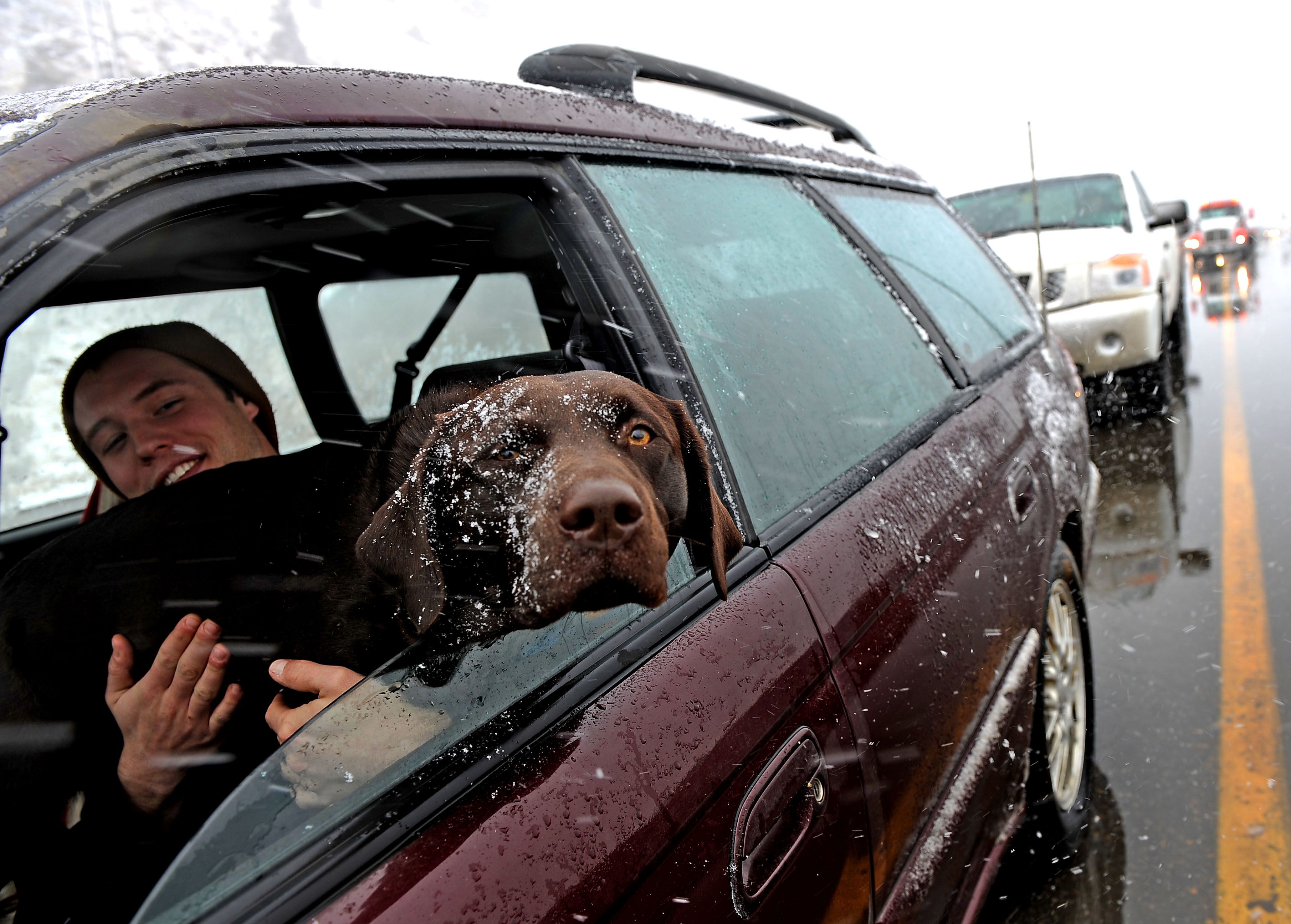 A driver who did not want to be identified and his dog wait out the weather in a long traffic jam on I-70. The two were headed to Breckenridge. After record breaking temperatures reached into the mid-80's yesterday, today April 3rd, 2011 a surprise spring storm from the north brought traffic to a stand still on both the east and west side of Eisenhower Tunnel along Highway I-70. Clear Creek county sheriff deputies closed the highway westbound at Georgetown and diverted traffic back towards Denver. Photo by Helen H. Richardson/The Denver Post (Photo By Helen H. Richardson/The Denver Post via Getty Images)