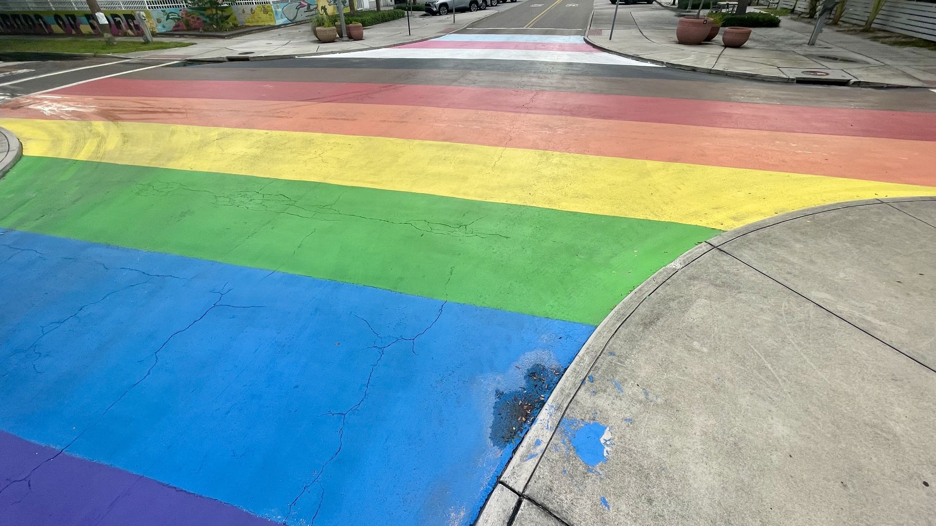 Rainbow-colored stripes — along with brown, black, white, pink and blue stripes painted at a four-way intersection.