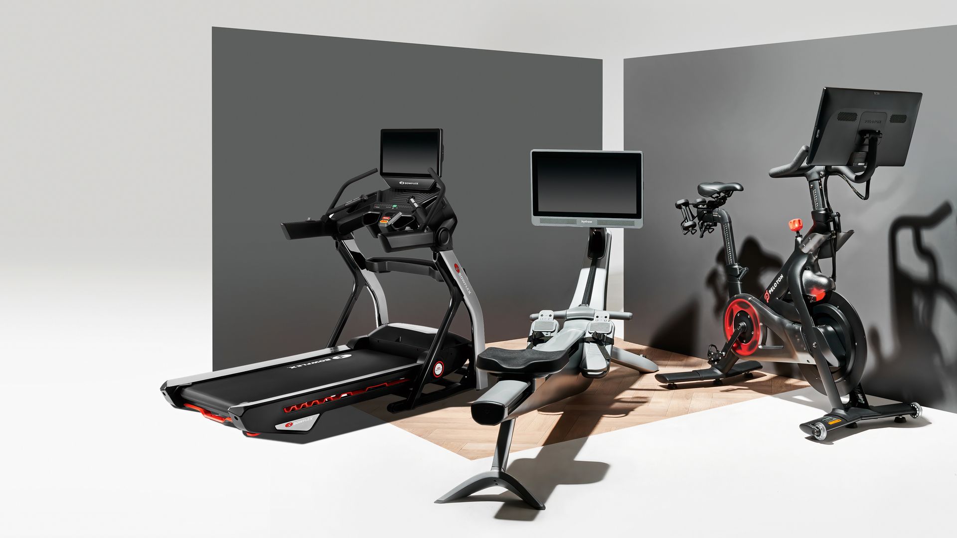 A group of home fitness machines, including a BowFlex treadmill on the far left.