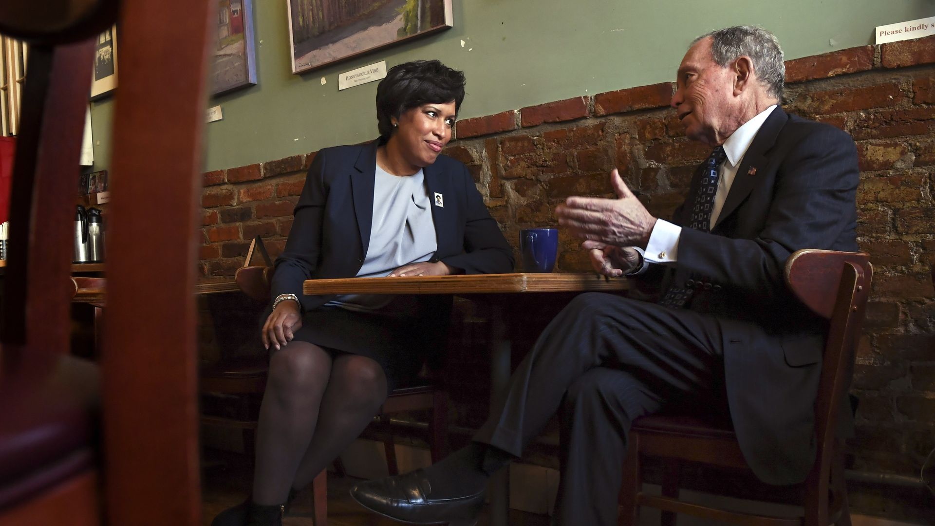 Muriel Bowser sits at a table with Mike Bloomberg