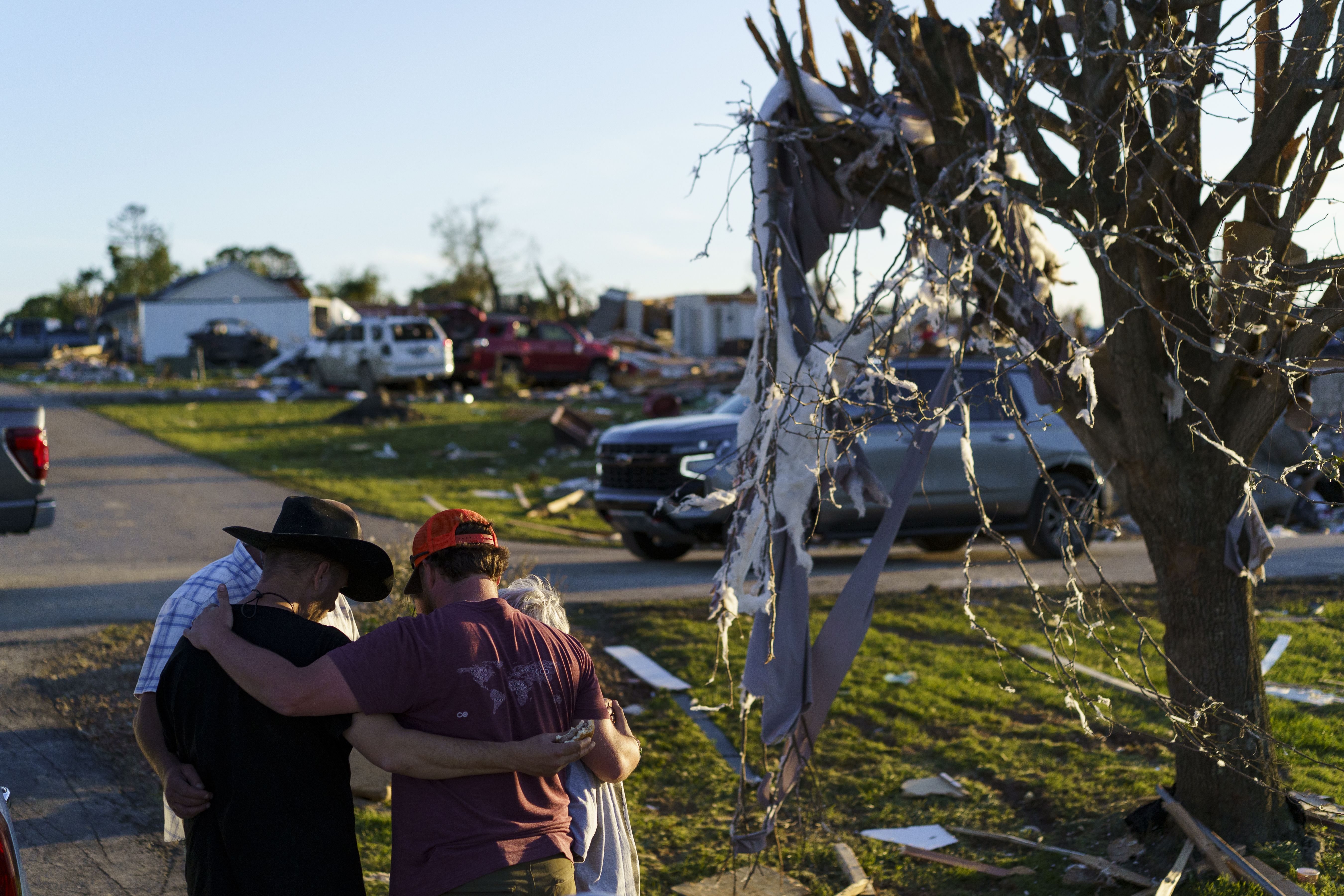People gather at the site of storm damage