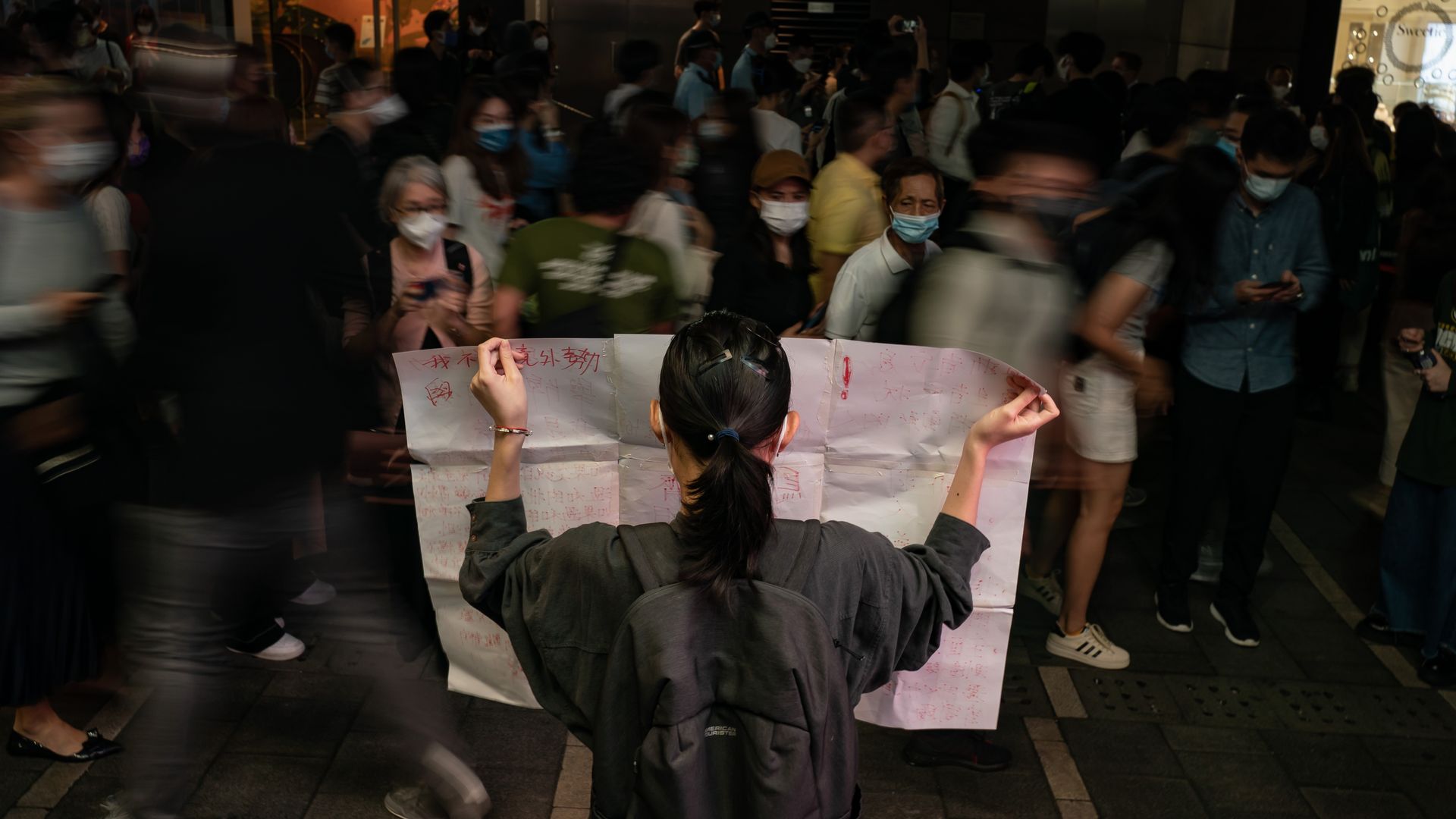 A resident holds a sign in protest of COVID restriction in mainland during a vigil in the central district on November 28, 2022 in Hong Kong, China.