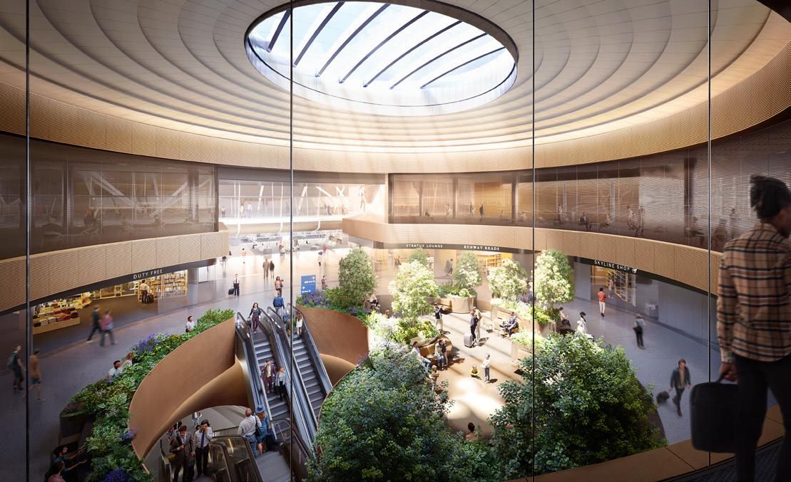 Modern circular atrium with a large skylight, greenery, benches, escalators, and people walking or sitting inside a spacious building with shops like Duty Free and Skyline Shop.