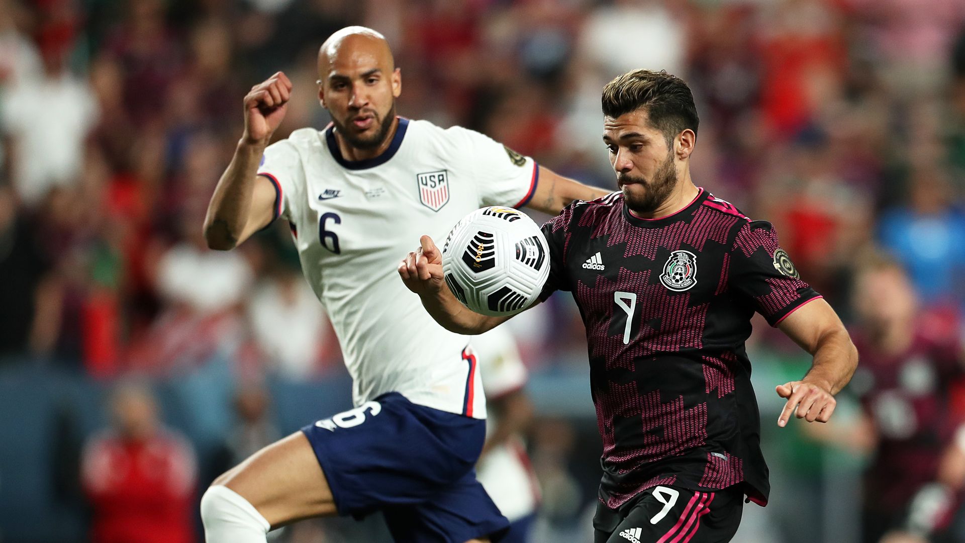 Photo of two soccer players aiming for the mid-air soccer ball on a field