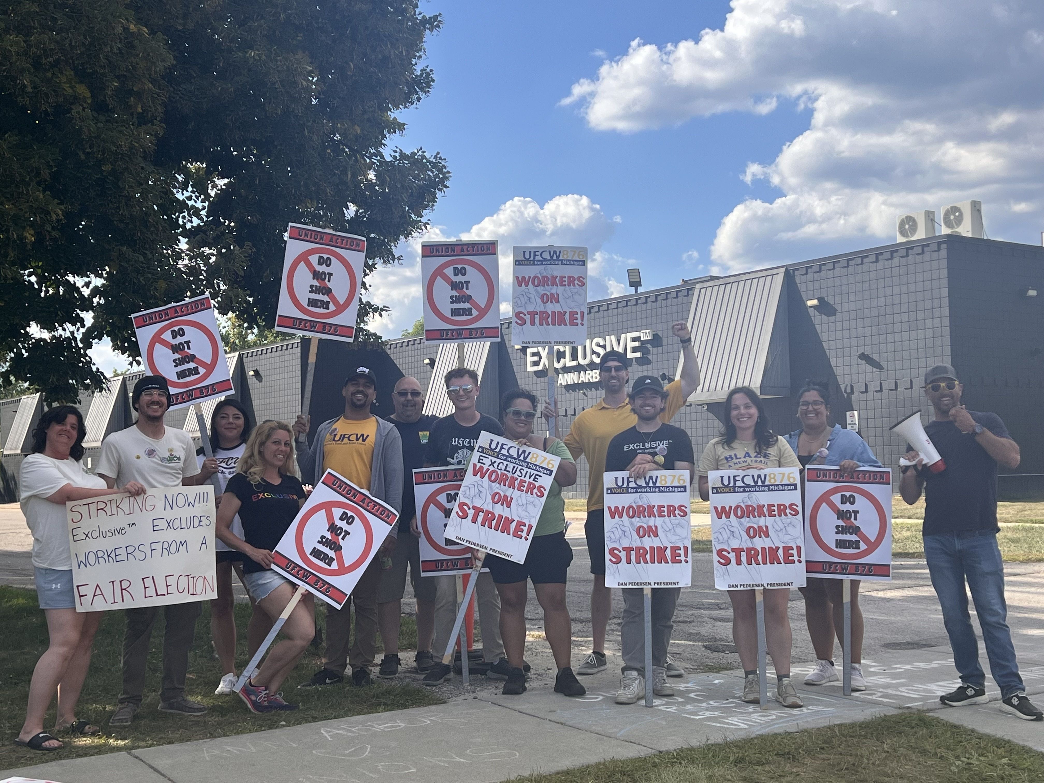 Workers hold up strike signs outside the shop
