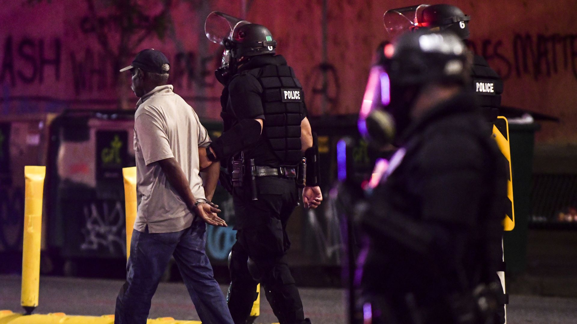 Police officers arrest a man in Denver, where a curfew sought to curb protests in 2020.