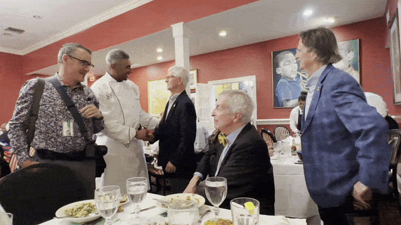 Image shows chef Dook Chase and Stella Reese Chase talking with diners.