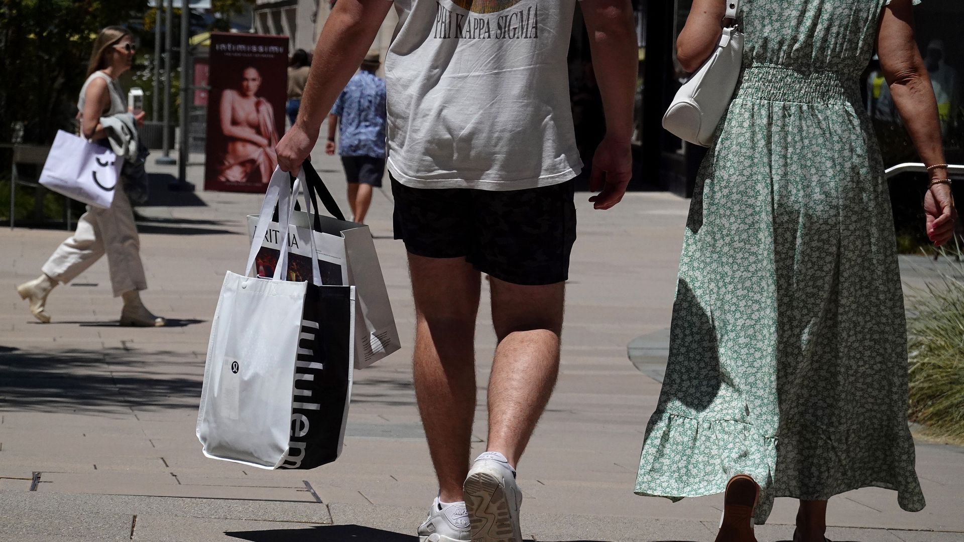 Shoppers walking down the street holding shopping bags