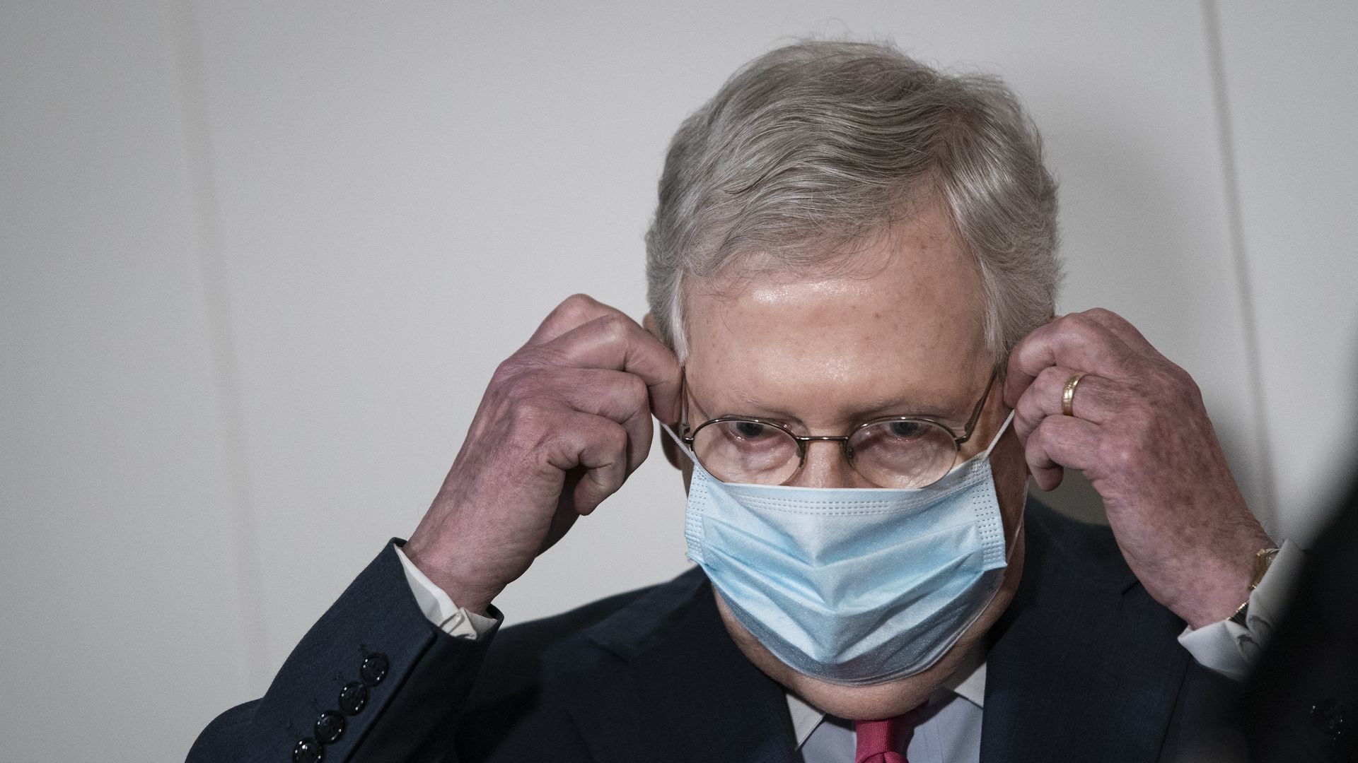 Senate Majority Leader Mitch McConnell puts on a mask after speaking to the press on Capitol Hill on May 19. 