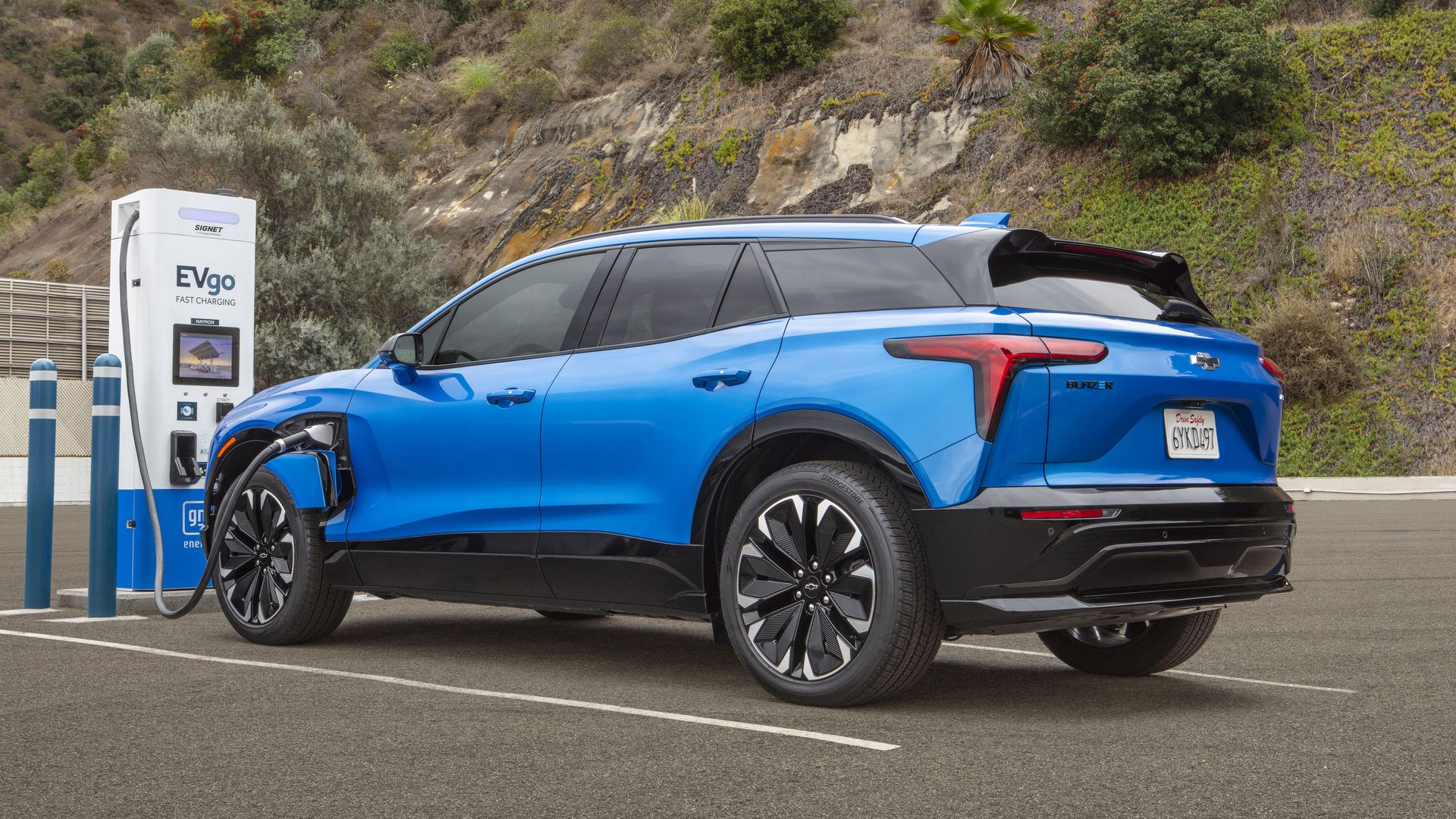Image of a Chevrolet Blazer EV plugged into a charging station at a rustic site