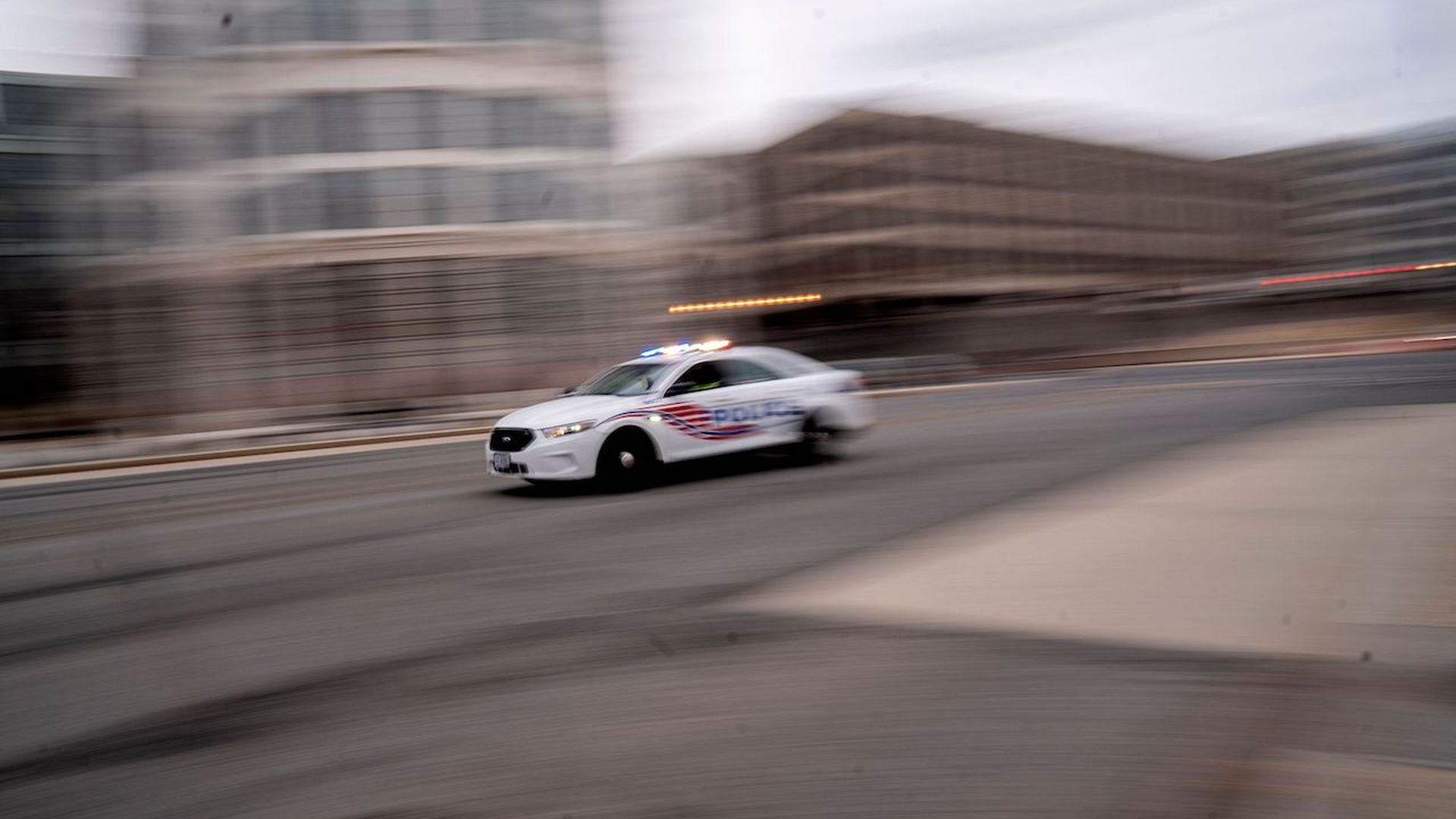 A police car drives through Washington, DC, on January 25, 2022. (Photo by Stefani Reynolds / AFP) (Photo by STEFANI REYNOLDS/AFP via Getty Images)