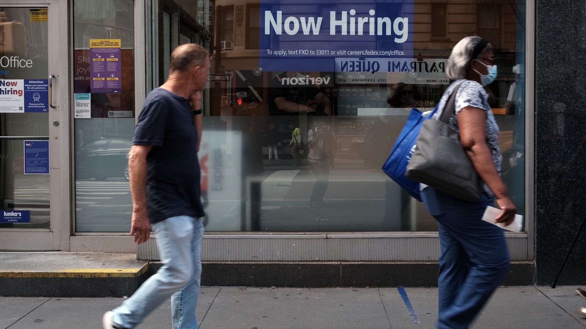 A "now hiring" sign hanging in a store window in New York City in August 2021.