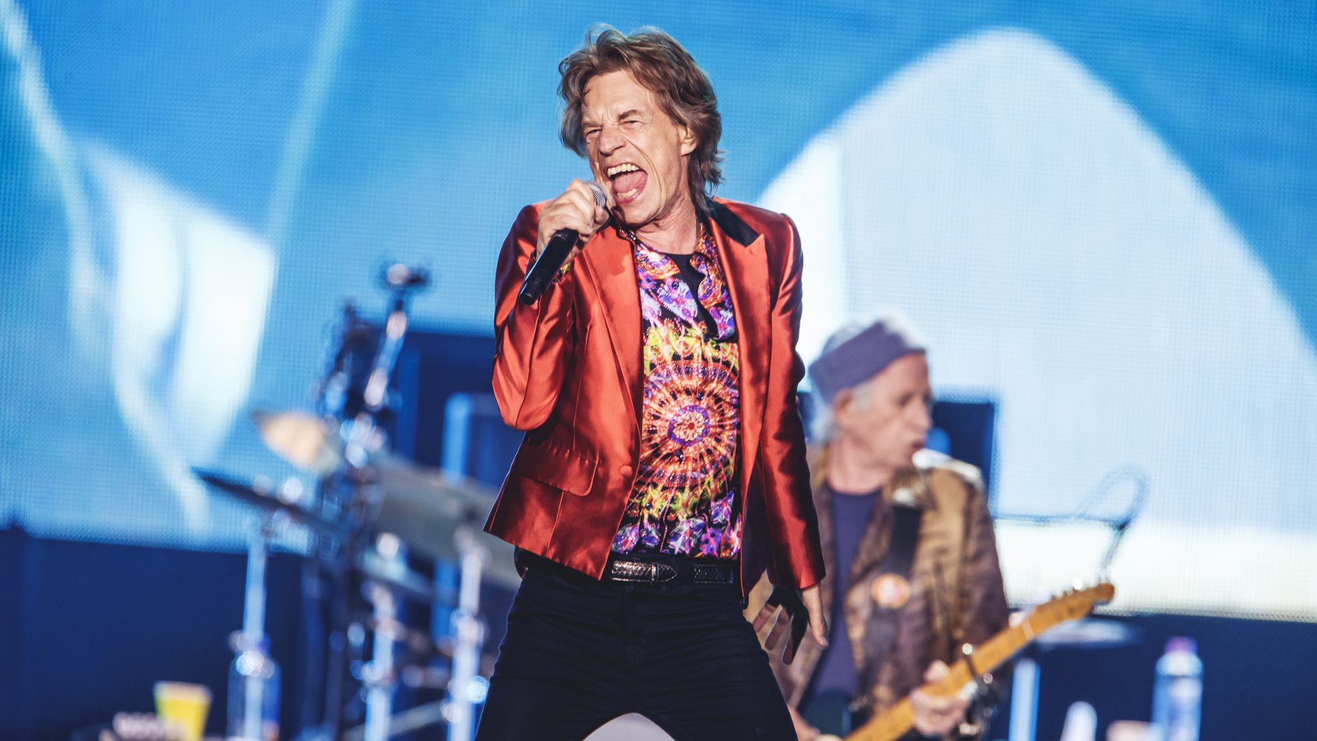 Mick Jagger performs on stage with Keith Richards behind him. 