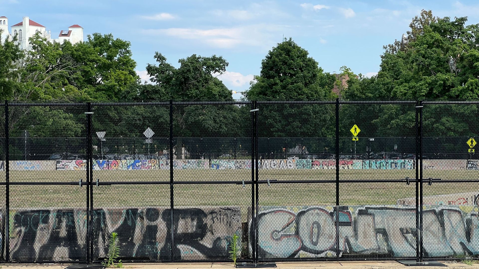 A tall fence around an empty field 