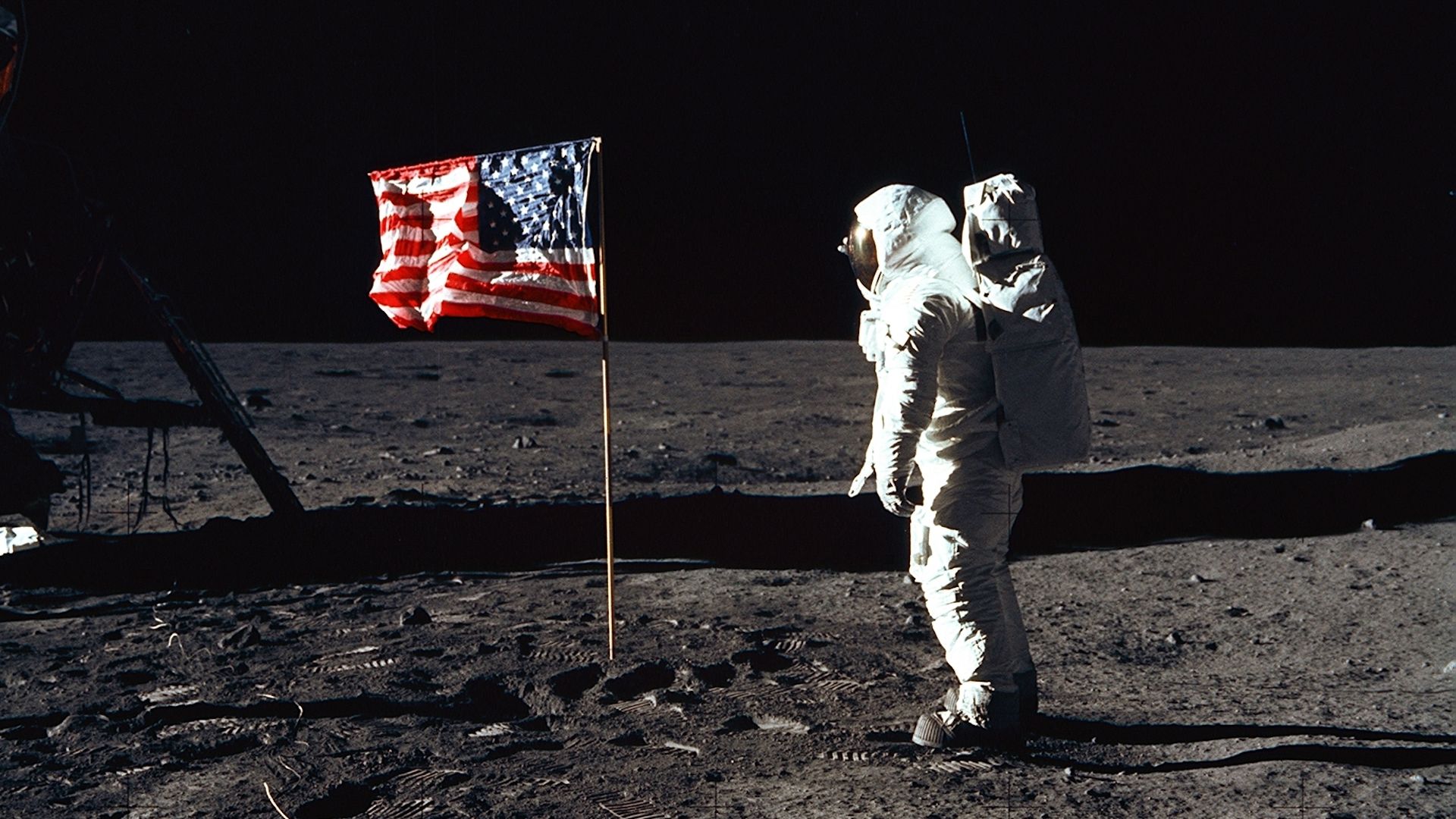 Astronaut Edwin E. Aldrin, Jr., the lunar module pilot of the first lunar landing mission, stands next to a United States flag July 20, 1969 during Apollo 11