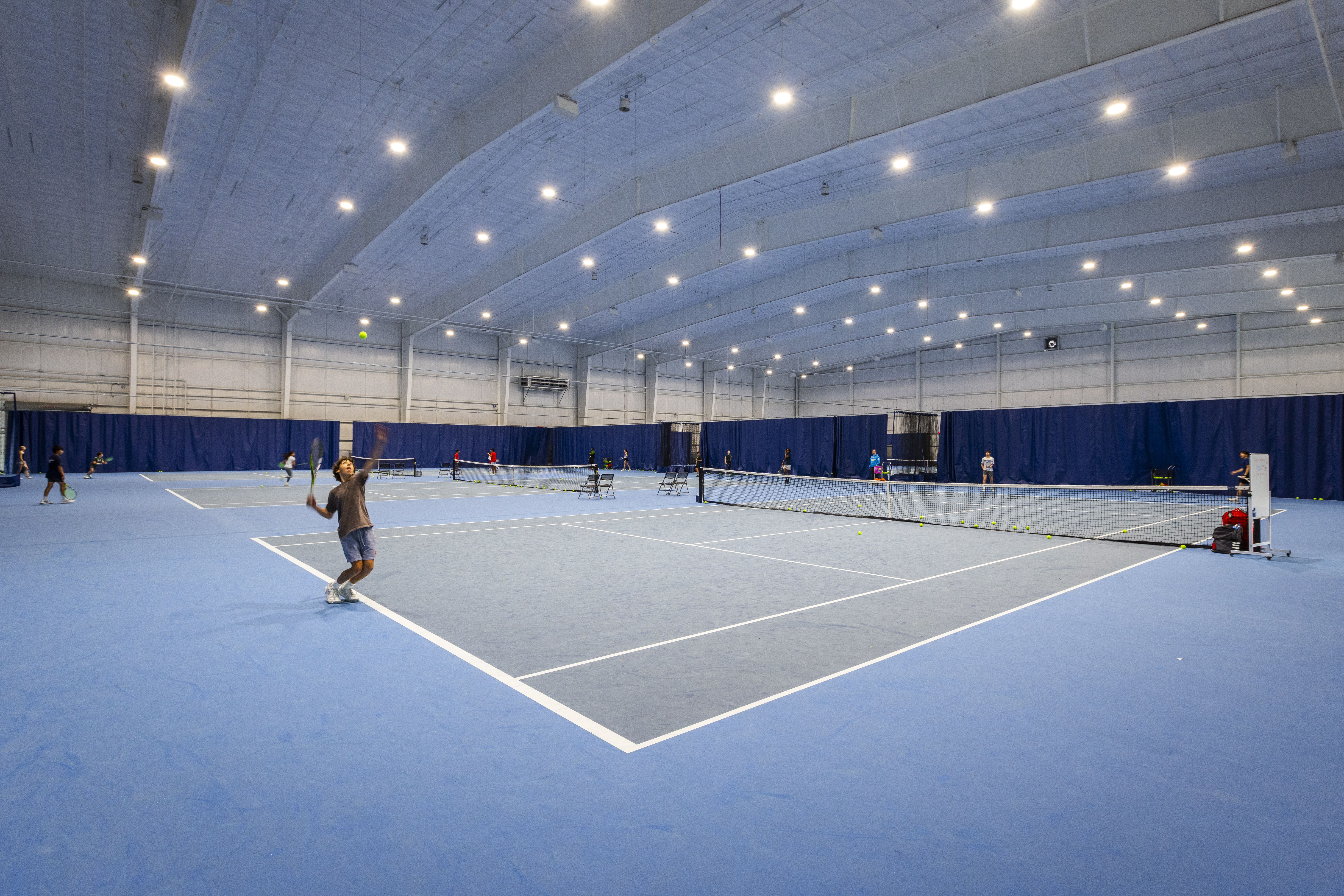 A photo of tennis players using the indoor courts at the Lindner Family Tennis Center in Mason, Ohio.