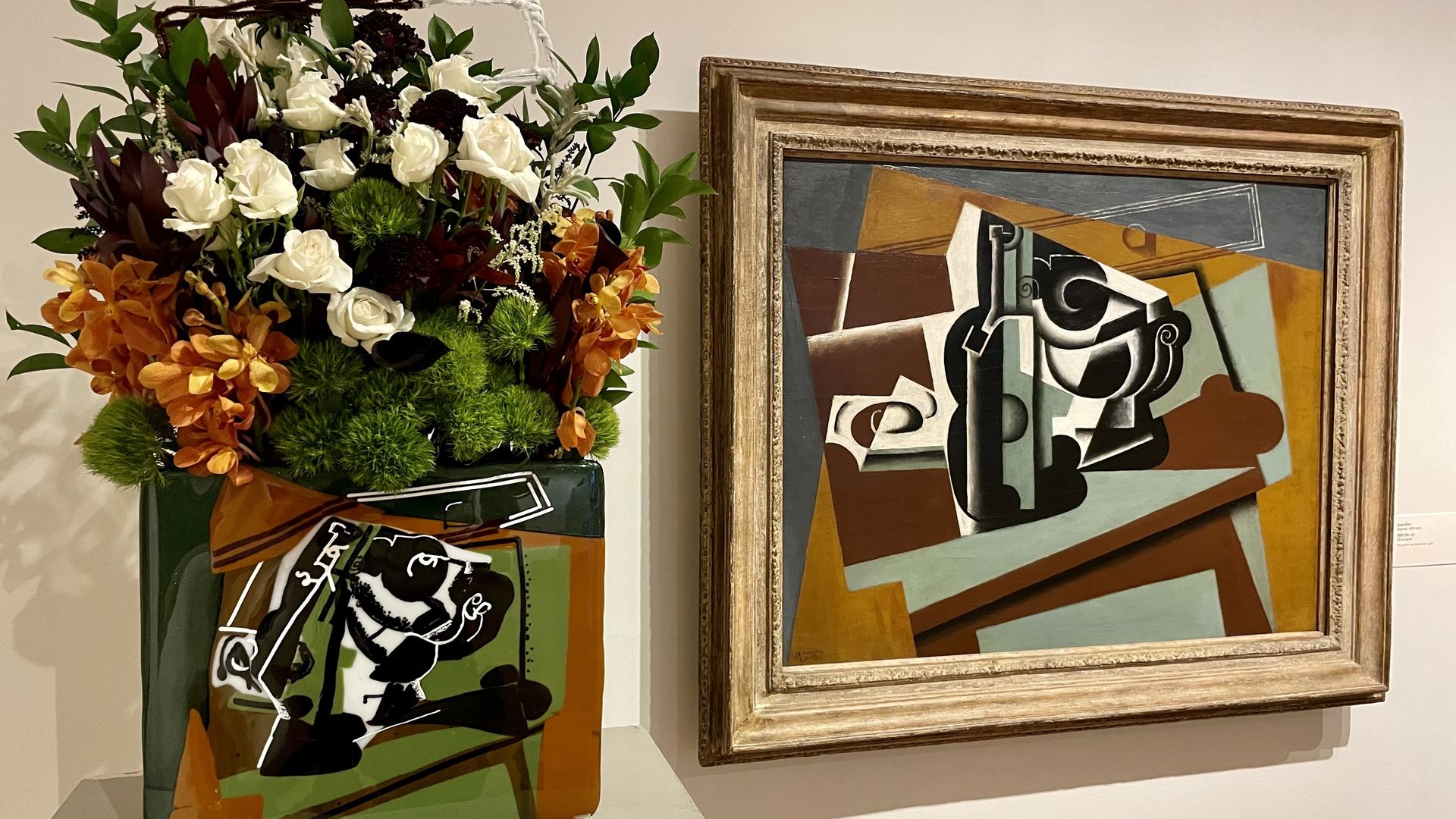 A floral arrangement next to a painting of squares.